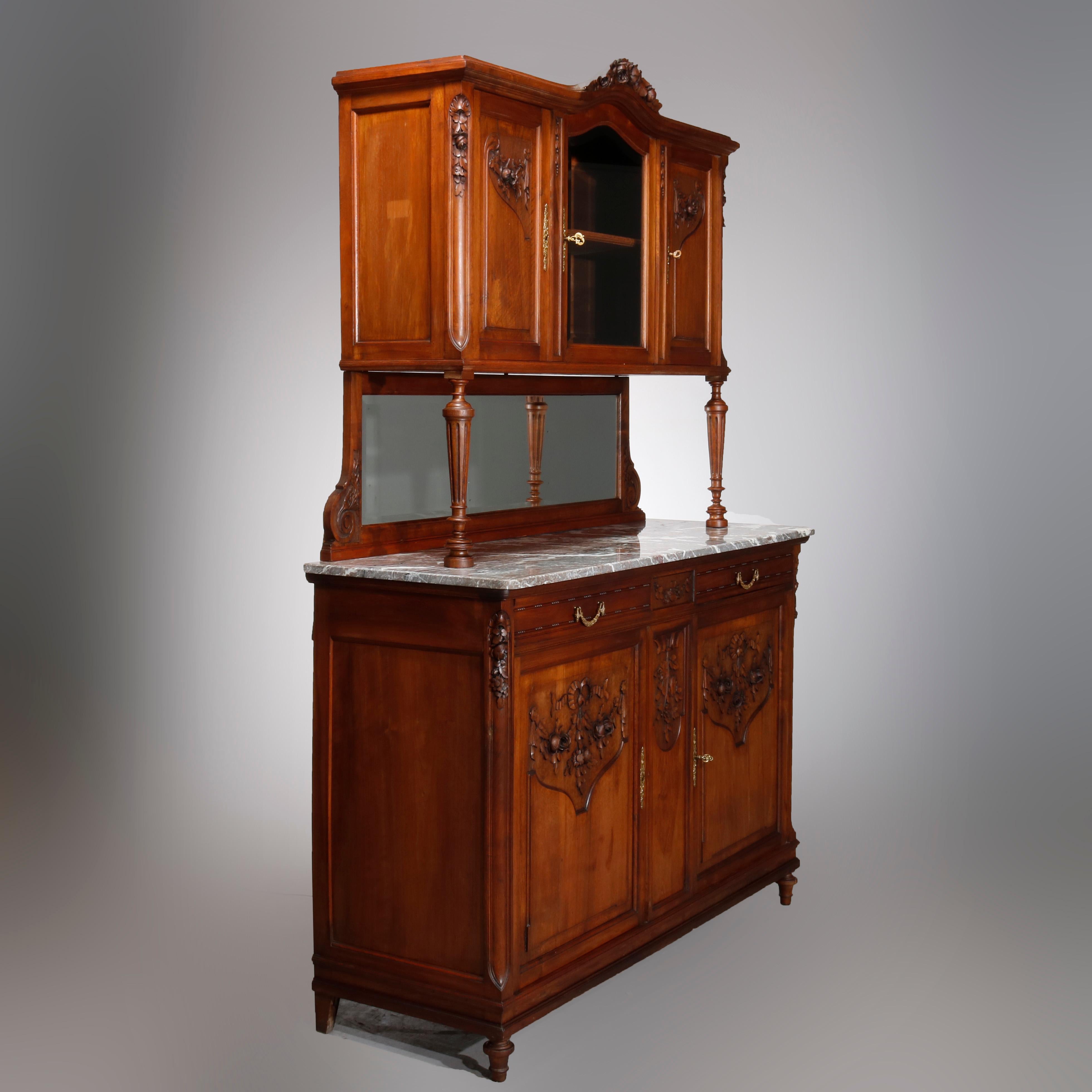 Antique French Louis XVI style carved walnut cupboard with triple door upper having arched floral crest surmounting glass center door over mirrored backsplash surmounting marble top double drawer and door lower having floral and tassel ribbon