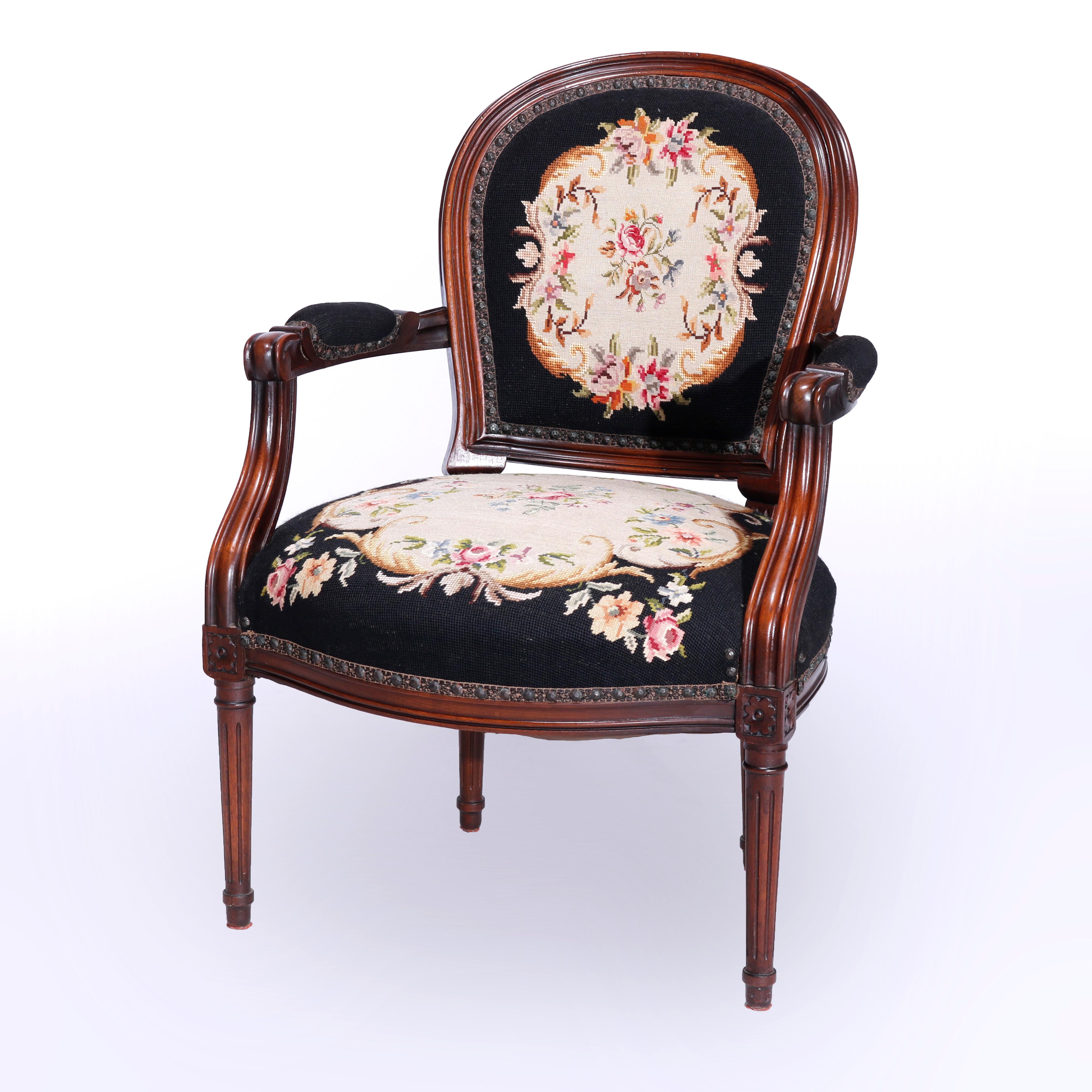 An antique French Louis XVI arm chair offers carved walnut frame with floral tapestry back seats and arms, raised on turned and reeded tapered legs, c1890

Measures - 33.75'' H x 23.5'' W x 26'' D; seat height 16''.

Catalogue Note: Ask about