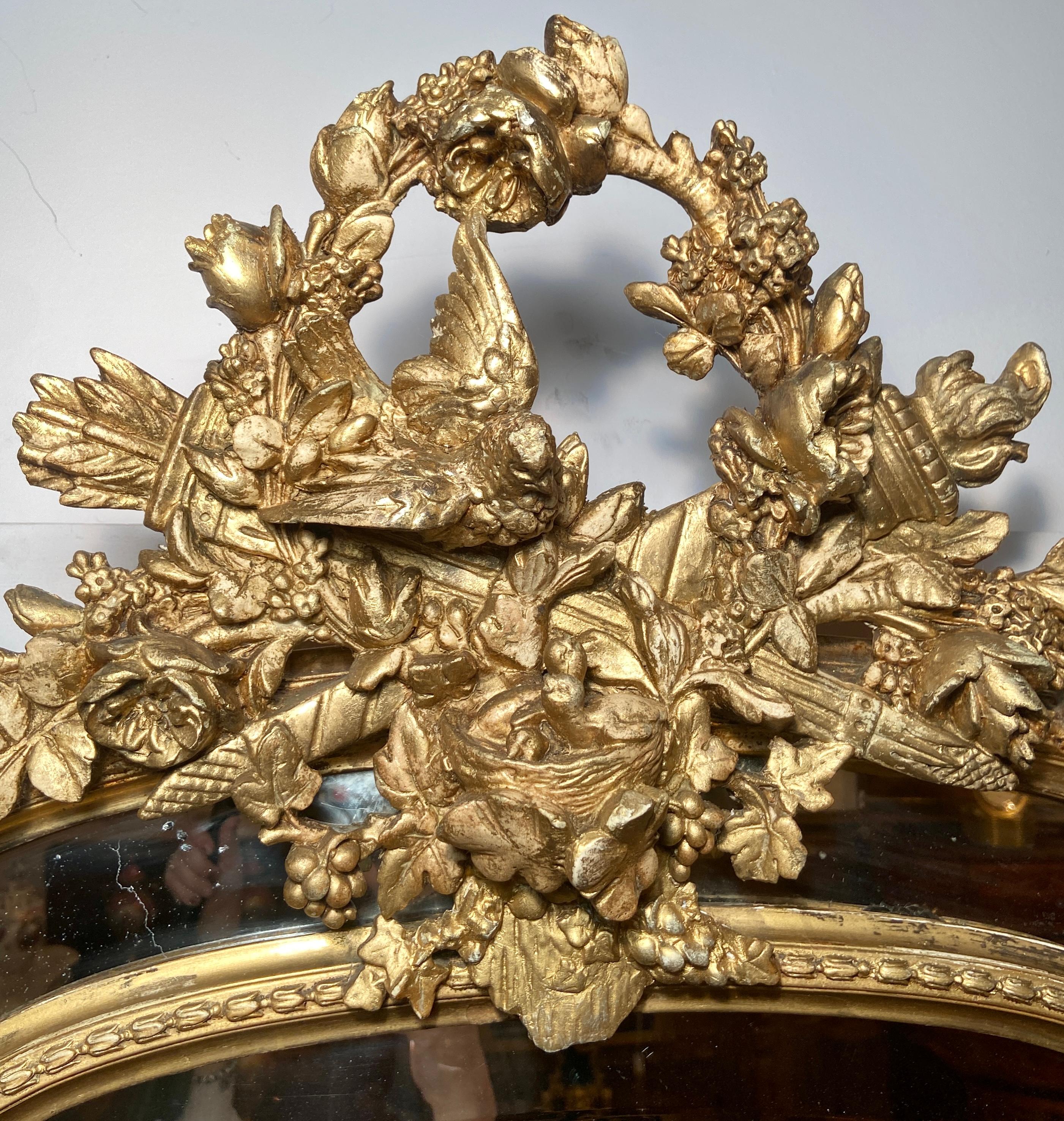 Antique miroir biseauté de style Louis XVI en bois sculpté de manière complexe avec feuilles d'or, vers 1890.