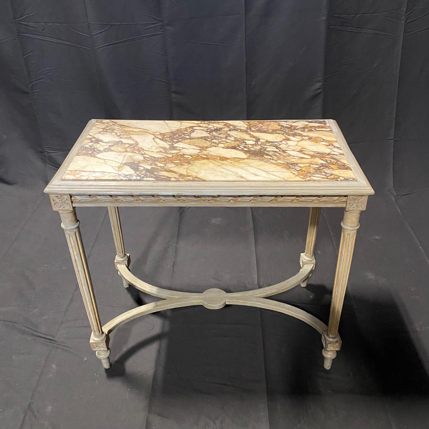  French Louis XVI style painted center or side table exceptionally executed and topped with a striking Breche d’Alep marble top over rectangular solid carved frame with early neutral grayish ivory paint.  The beautiful apron is accented with carved
