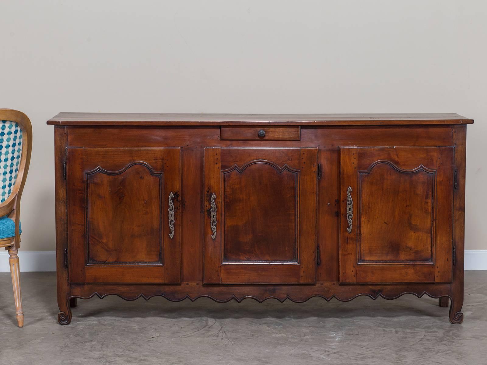 The lush colour and patina of this antique French Louis XVI period credenza buffet enfilade from France circa 1780 enhances the carved details that give this Louis XVI period cherrywood buffet its lasting appeal. One of the most interesting features