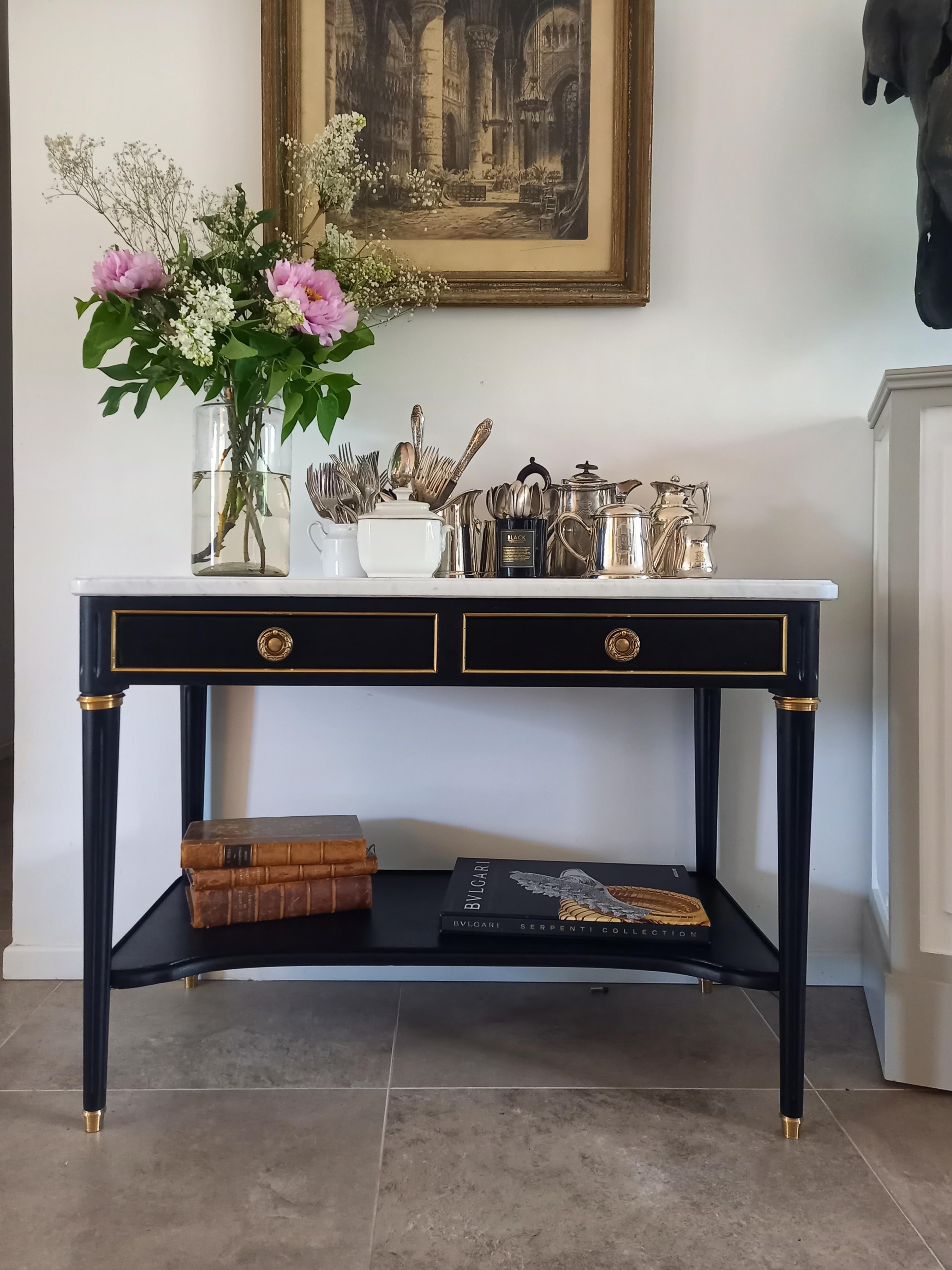 French Louis XVI style console topped with white Carrara marble embellished with a lower wooden shelf.
Two drawers in front, fluted legs elegantly decorated with gilt bronze rings and clogs.

Perfect in a hall, also to create a small whiskey bar
