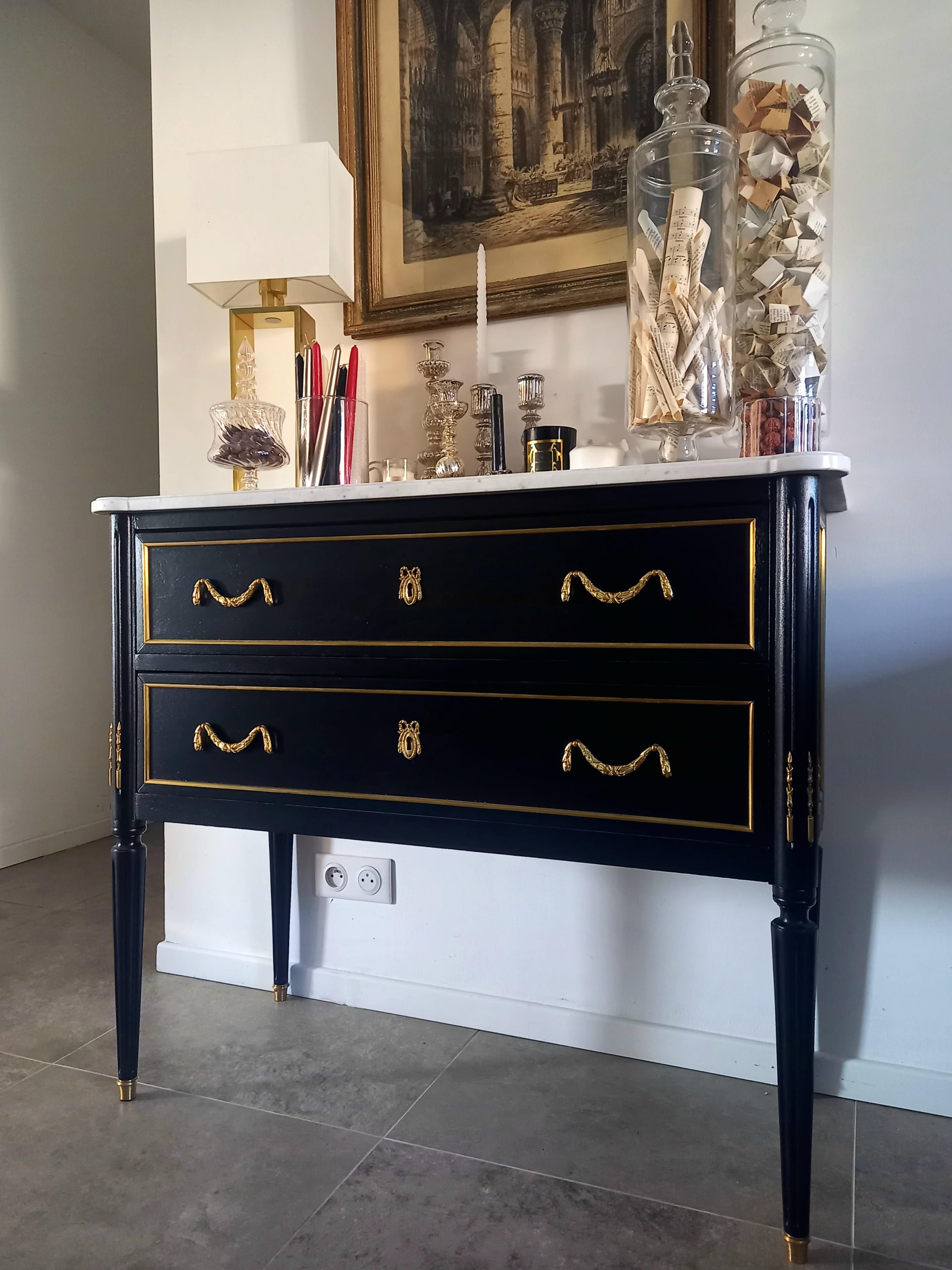 Antique French Louis XVI style chest of drawers topped with a white Carrara marble, fluted legs finished with golden bronze clogs.
The handles are in the shape of bronze ribbons, and pretty details decorate the uprights of the furniture, bringing a