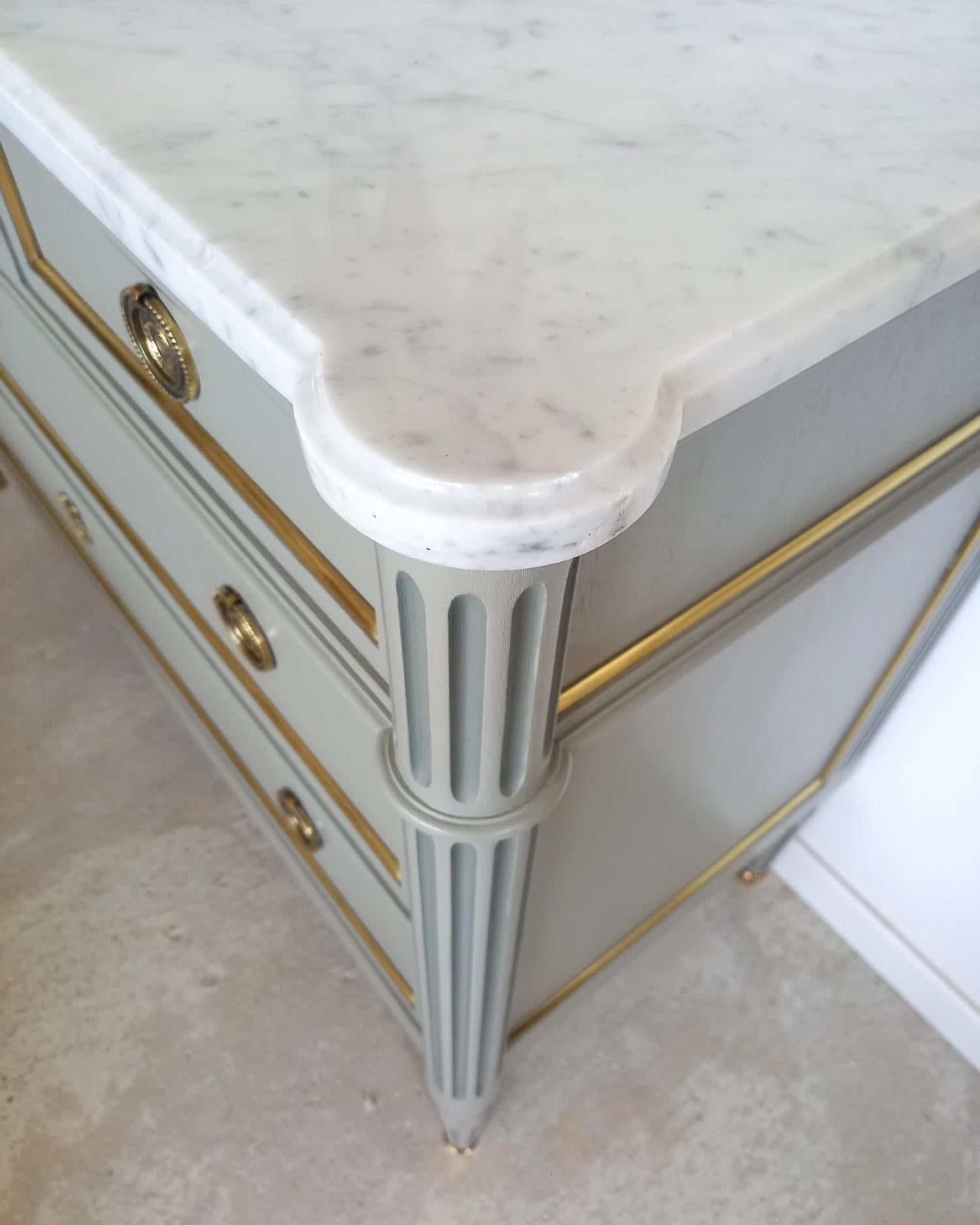 Antique French, Louis XVI style chest of drawers topped with a white Carrara marble, fluted legs finished with golden bronze clogs. 
Five dovetailed drawers with brass details, and a key, all parts are original.

