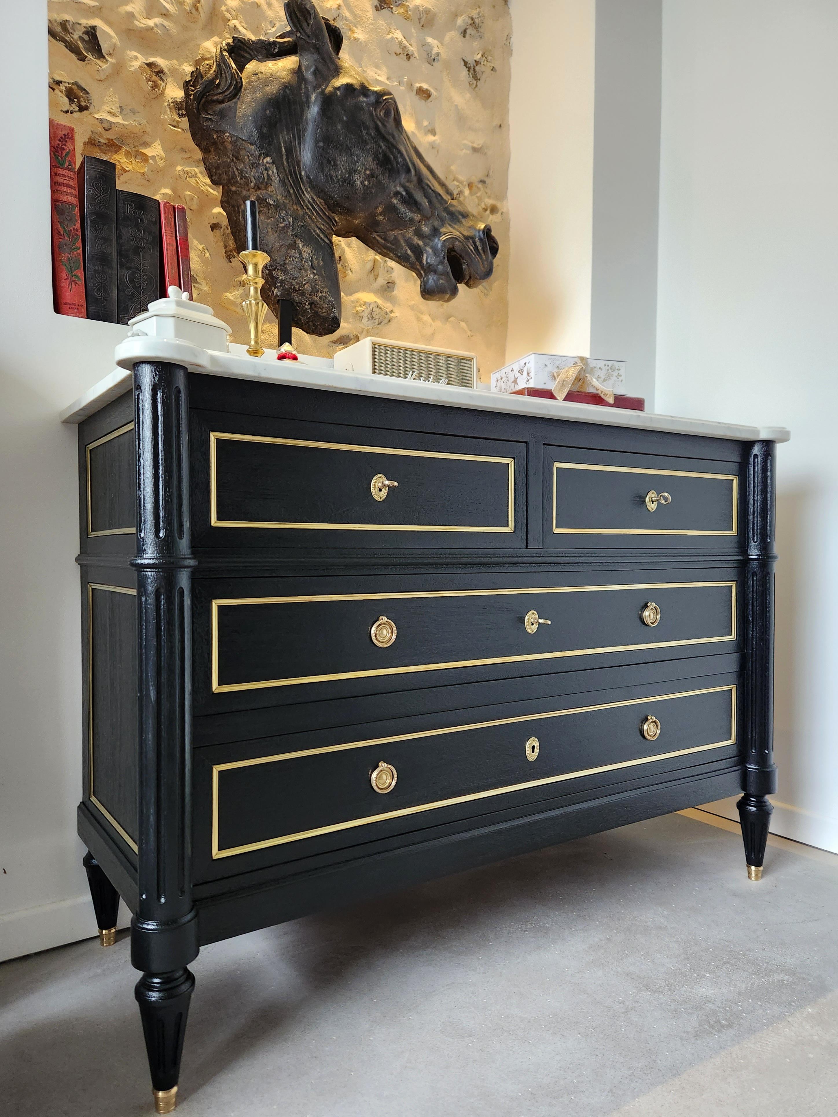 Antique French, Louis XVI style chest of drawers topped with a white Carrara marble, fluted legs finished with golden bronze clogs. 
Four dovetailed drawers with brass details, and three keys.
 