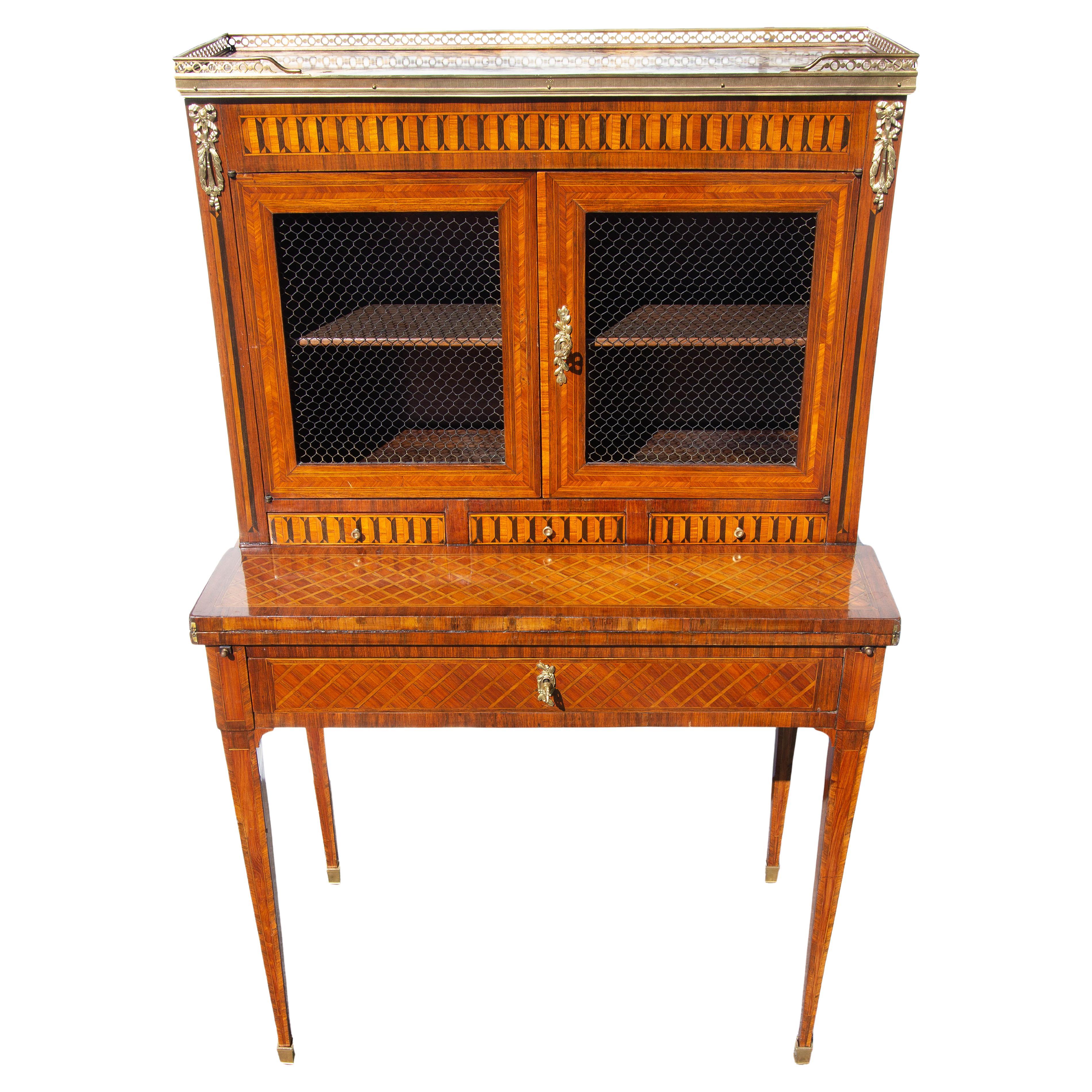 Antiguo escritorio bonheur du jour estilo Luis XVI. Finas incrustaciones de parquet de madera de rey. Monturas de bronce dorado. Tapa de mármol labrado. Circa 1850. Ponte en contacto con Joseph Dasta Antiques para conocer las opciones de envío. 

Un