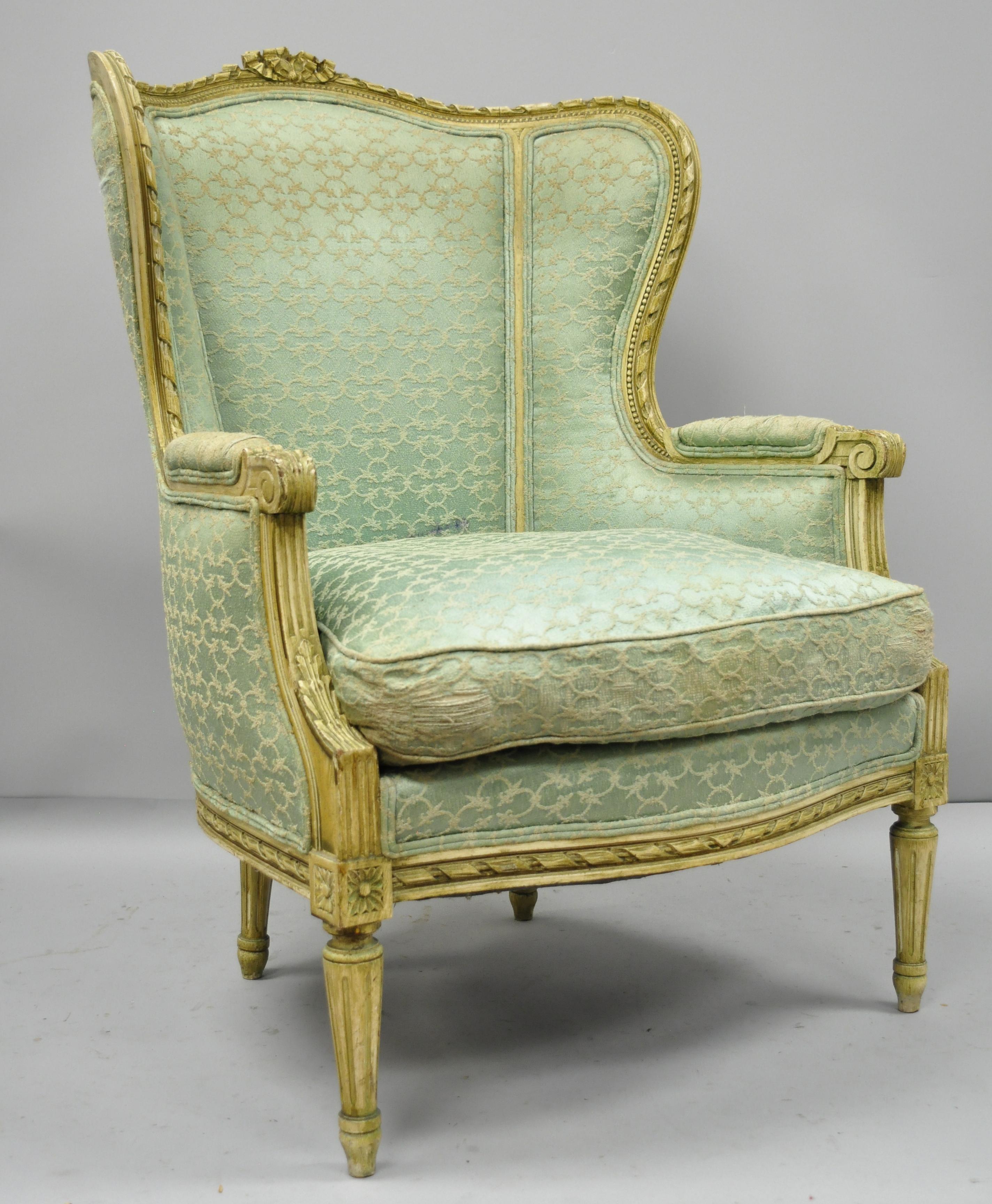 Antique French Louis XVI distress painted cream armchair. Item features shapely wingback, finely carved frame, cream distressed finish, solid wood frame, and tapered legs, circa early 20th century. Measurements: 41.5