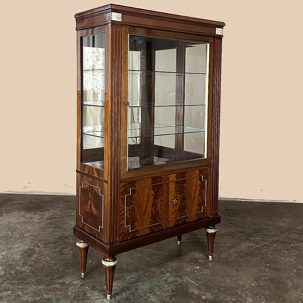 Antique French Louis XVI Flame Mahogany Vitrine is the perfect choice to display your family heirlooms, special collection, or just a seasonal display!  Hand-crafted from imported mahogany, it features flame pattern veneers on the front and sides. 