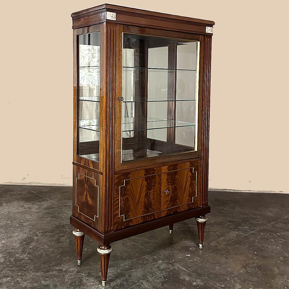 La vitrine ancienne en acajou de style Louis XVI est le choix idéal pour exposer vos objets de famille, votre collection spéciale ou simplement pour une exposition saisonnière !  Fabriqué à la main à partir d'acajou importé, il présente des placages