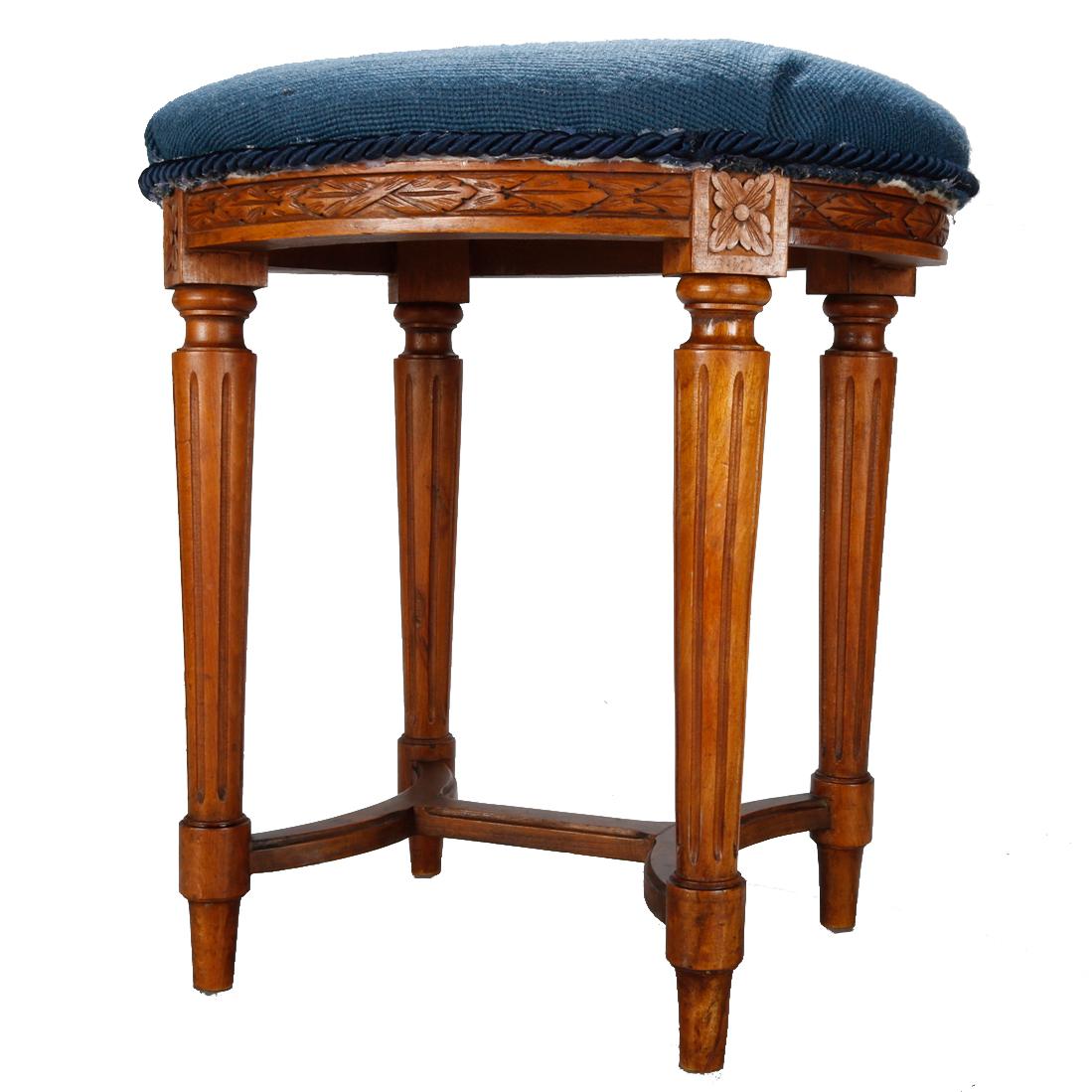 An antique French Louis XVI stool offers floral needlepoint upholstered seat surmounting fruitwood base with carved foliate and rosette elements, raised on tapered and fluted legs having stylized stretcher, 19th century

Measures: 18.5