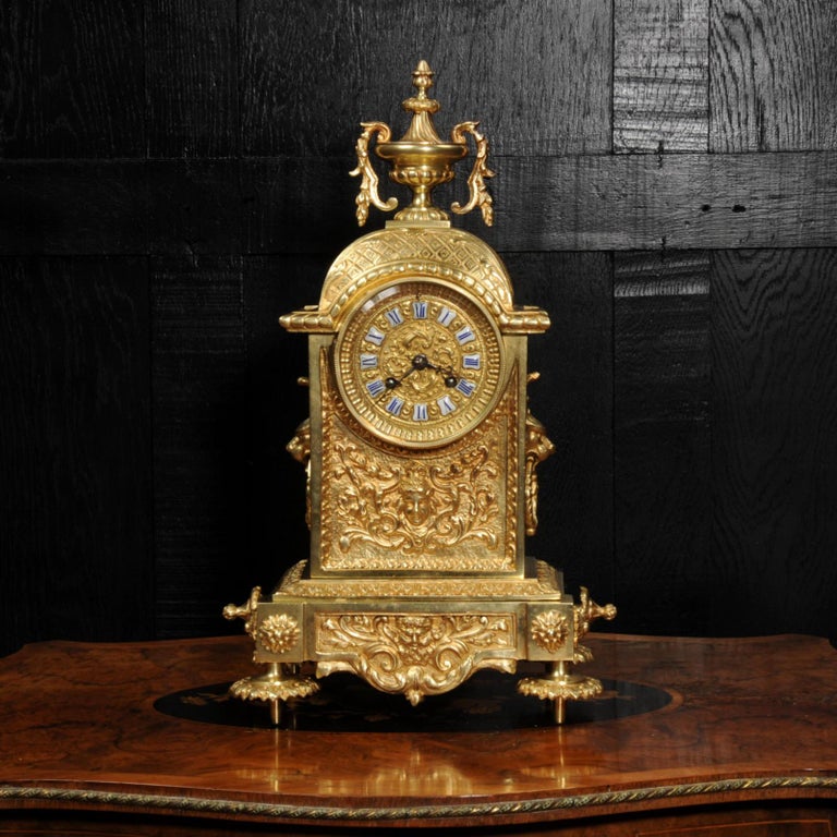 A stunning original antique French gilt bronze clock in the classical style of Louis XVI, circa 1880. A beautifully restrained architectural case with lions mask handles and an urn with tumbling foliage. Panels to the front have goddess and mythical