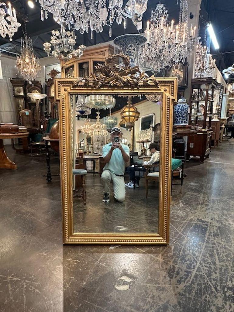19th century elegant French Louis XVI giltwood mirror. Featuring elaborate carvings and a beautiful gold gilt. Exceptional!!