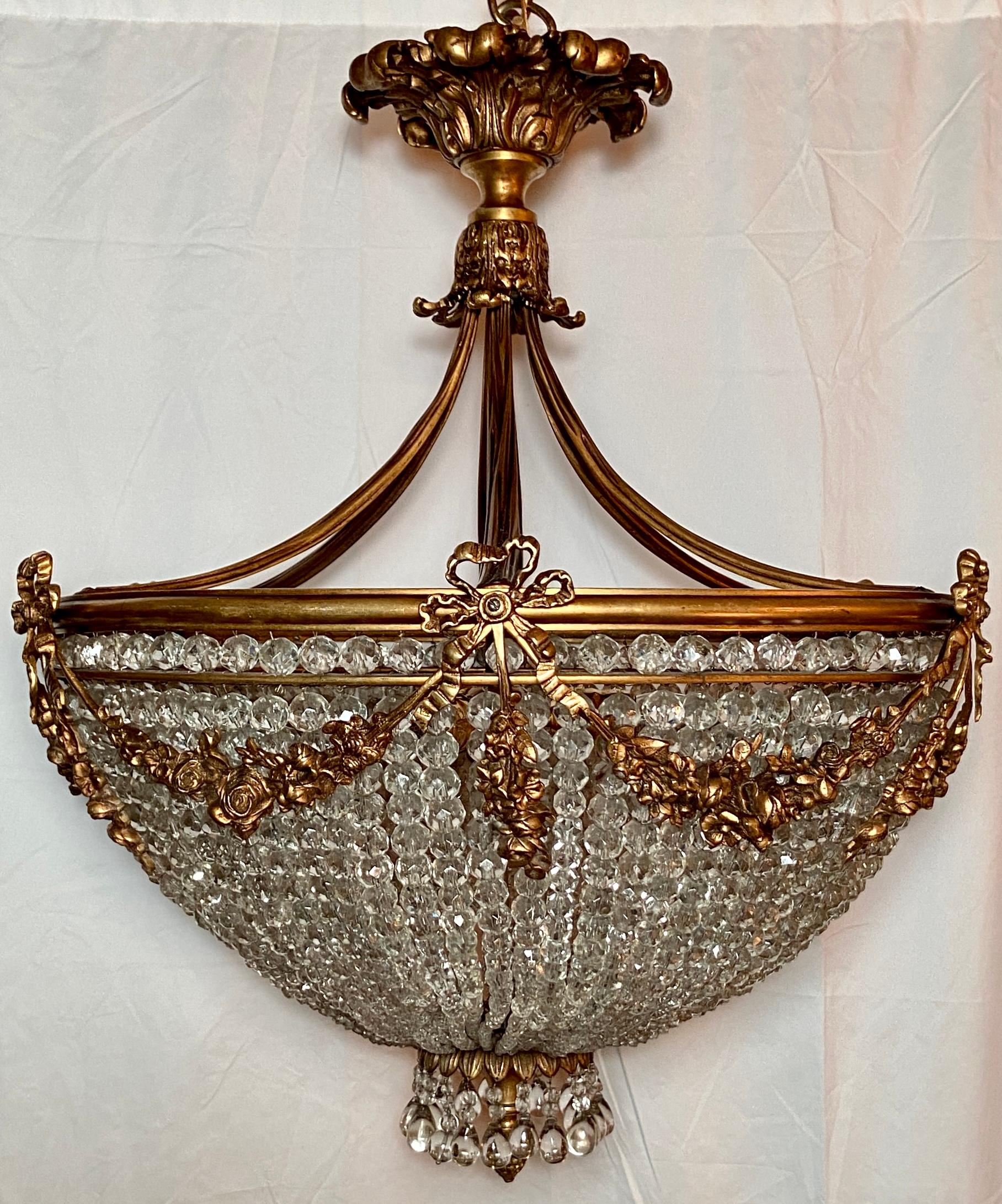 Antique French Louis XVI Gold Bronze and Crystal Chandelier.
The ribbons and garlands gracing this chandelier make it very appealing, in addition to the nice draping of the crystal strands. The fixture could be flush mounted if ceiling heights were