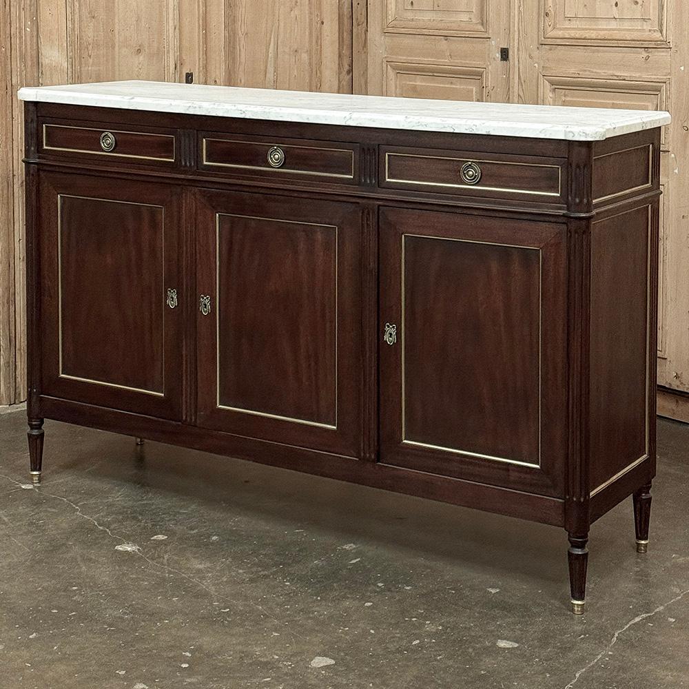 L'Antique French Louis XVI Mahogany Buffet with Carrara Marble sarà un'ottima aggiunta a qualsiasi stanza!  L'architettura sartoriale e rettilinea affonda le sue radici nei giorni di gloria dell'antica Grecia e Roma, con tocchi sottili che emanano