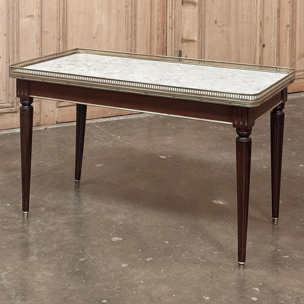 Antique French Louis XVI Mahogany Coffee Table with Carrara Marble is perfect for adding the finishing formal touch to your entertaining room.  Tailored lines include an apron bordered with brass trim connecting four tapered and fluted legs tipped