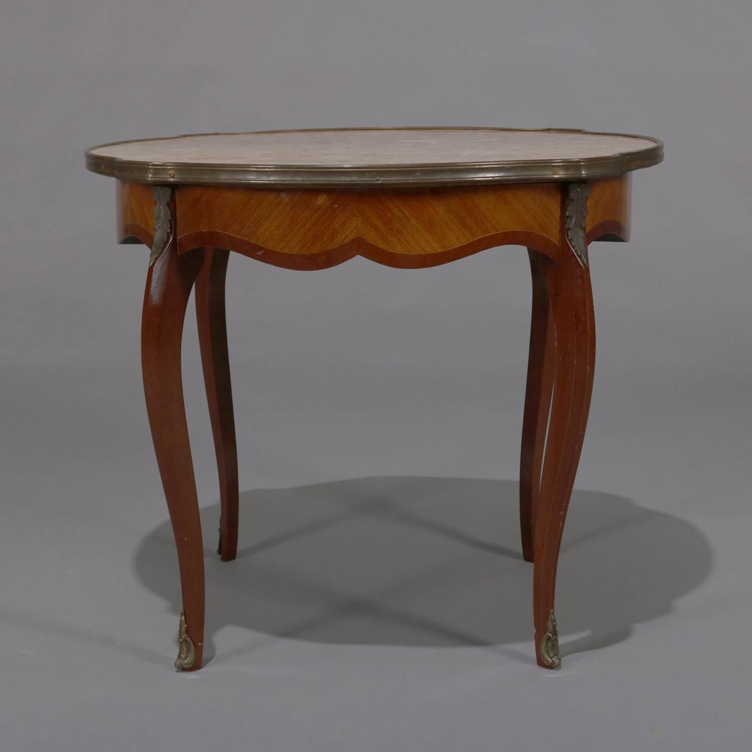 Antique French Louis XVI low table features mahogany construction with shaped top having inset marble top and bronze banding over scalloped skirt with bookmatched kingwood inlay panels, raised on cabriole legs with cast bronze acanthus and foliate