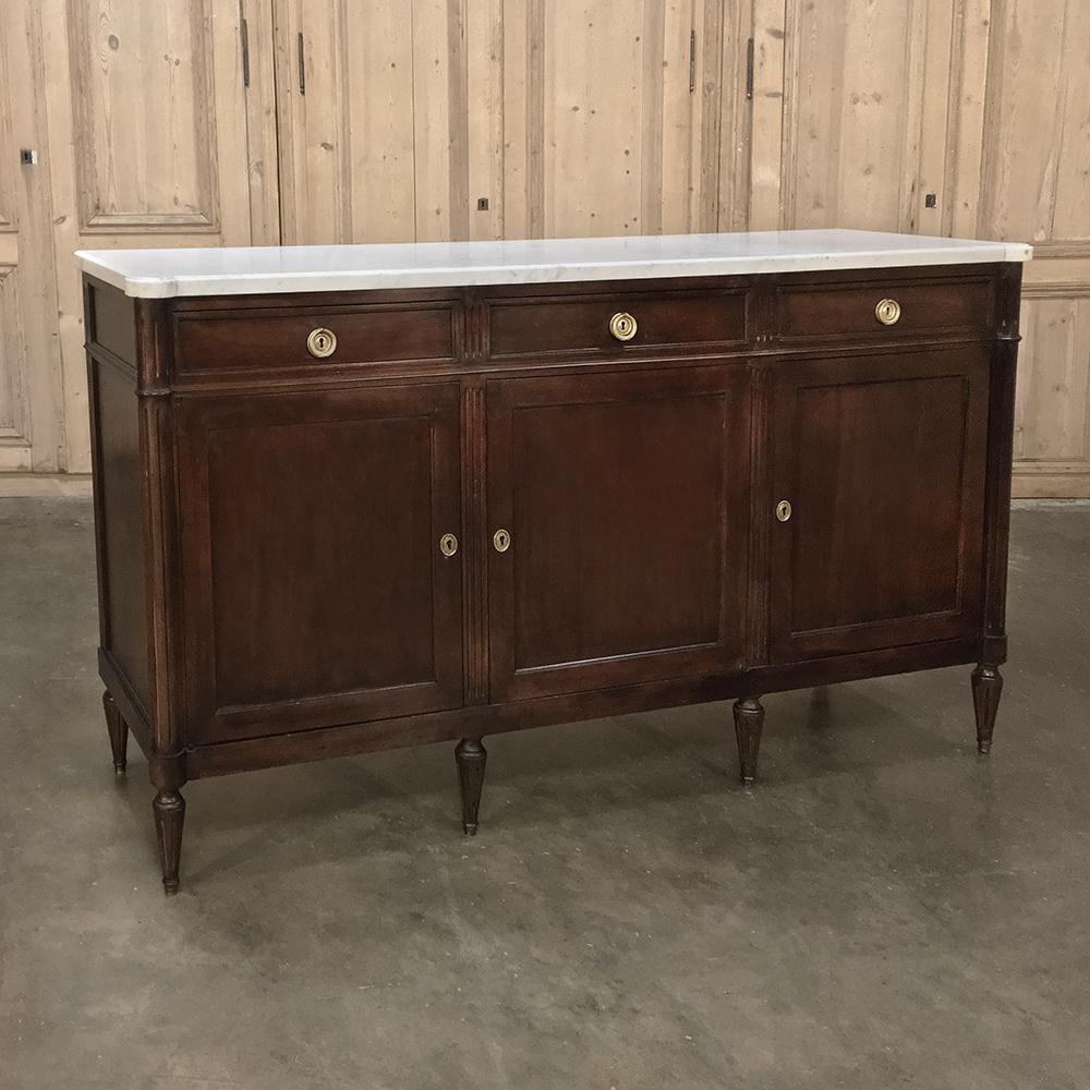 Antique French Louis XVI mahogany marble top buffet is a perfect example of the style, with tailored architecture devoid of carved embellishment that draws special attention to the sheer natural beauty of the exotic imported mahogany of which the