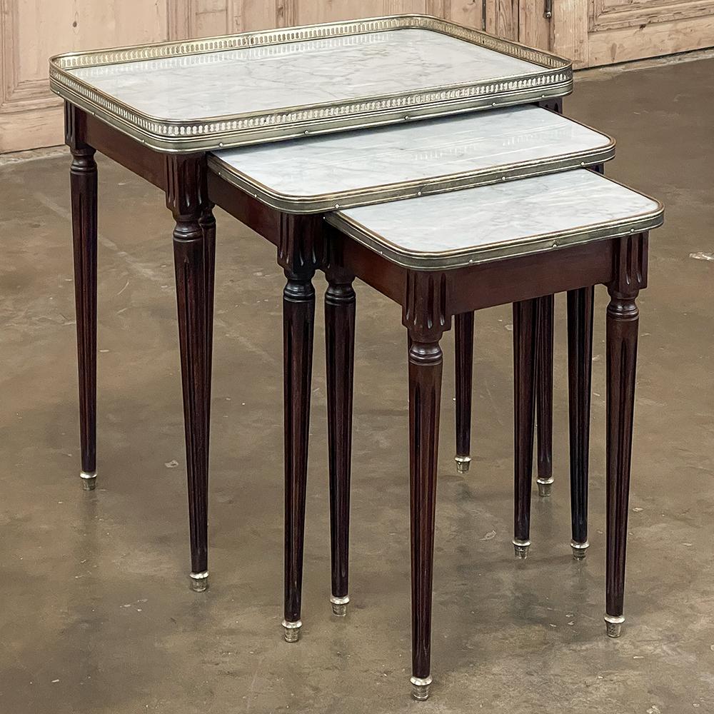 Antique French Louis XVI Mahogany Nesting Tables with Carrara Marble Tops will add elegance, style and convenience to any room, all in one beautiful set! Three tables in one, each features exquisite imported mahogany with elegantly tapered legs that