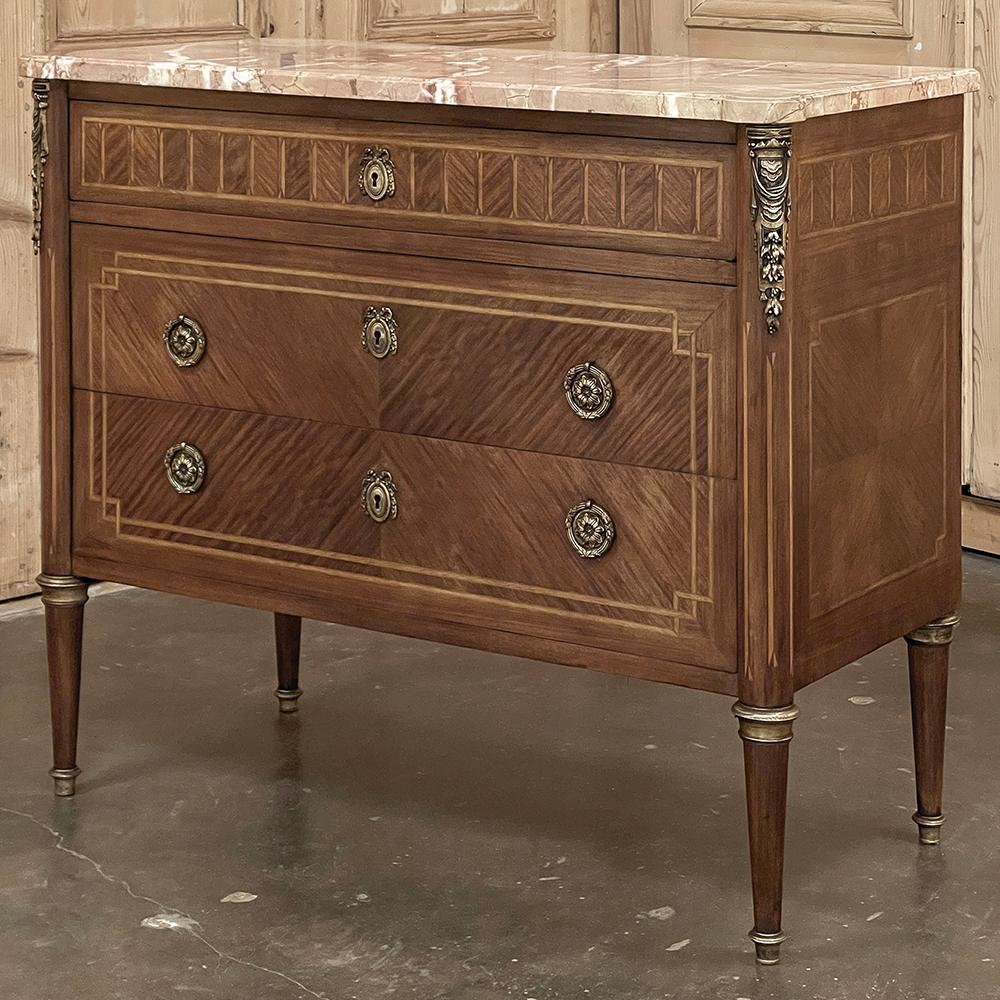 Antique French Louis XVI Marble Top Marquetry Commode is yet another example of the fine craftsmanship we've come to admire from French artisans!  The rectilinear casework is enhanced by rounded corners in front that feature trompe l'oeil fluting