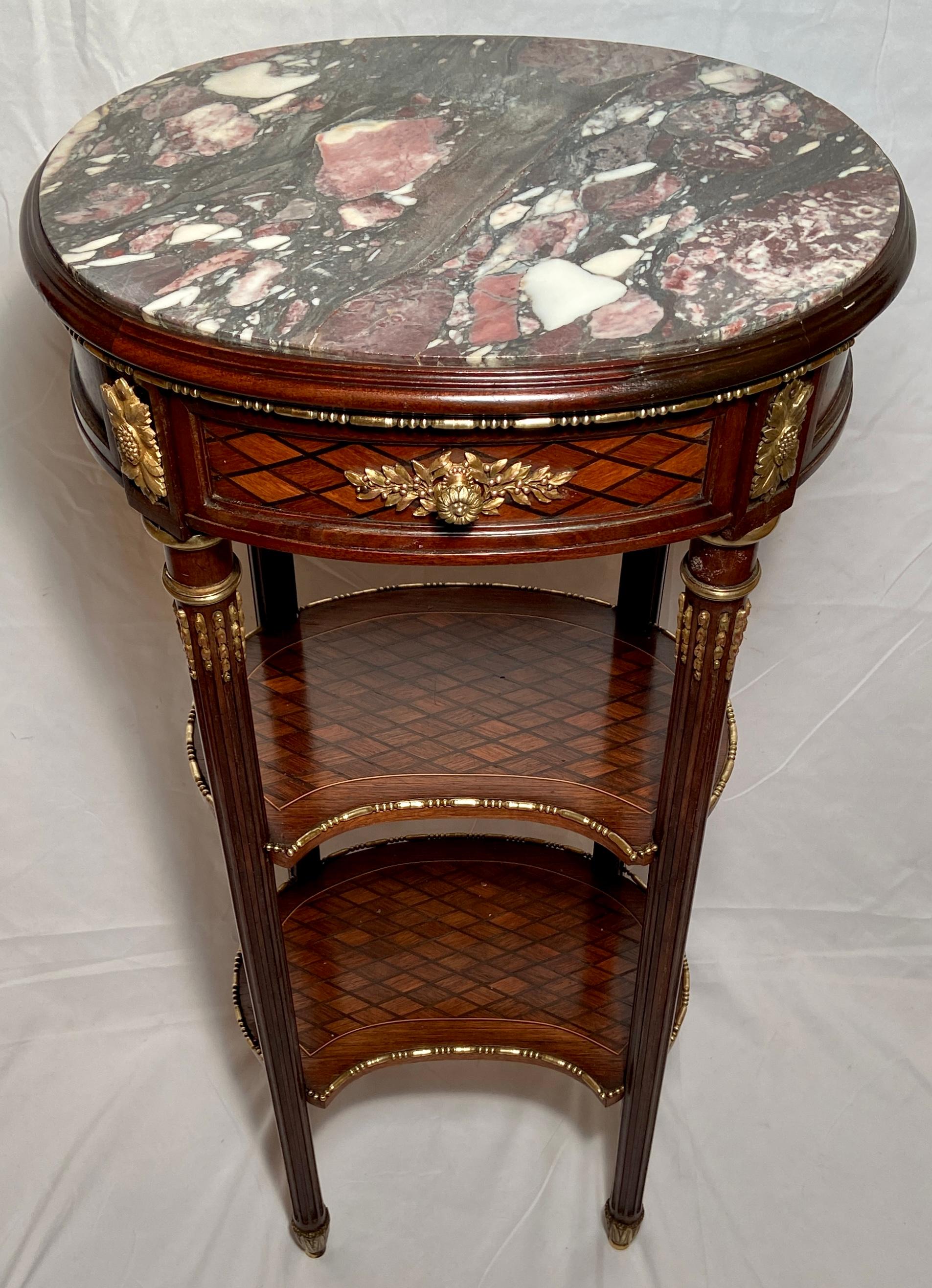 Antique French Louis XVI marble-top occasional table with exotic wood inlay and ormolu trim.