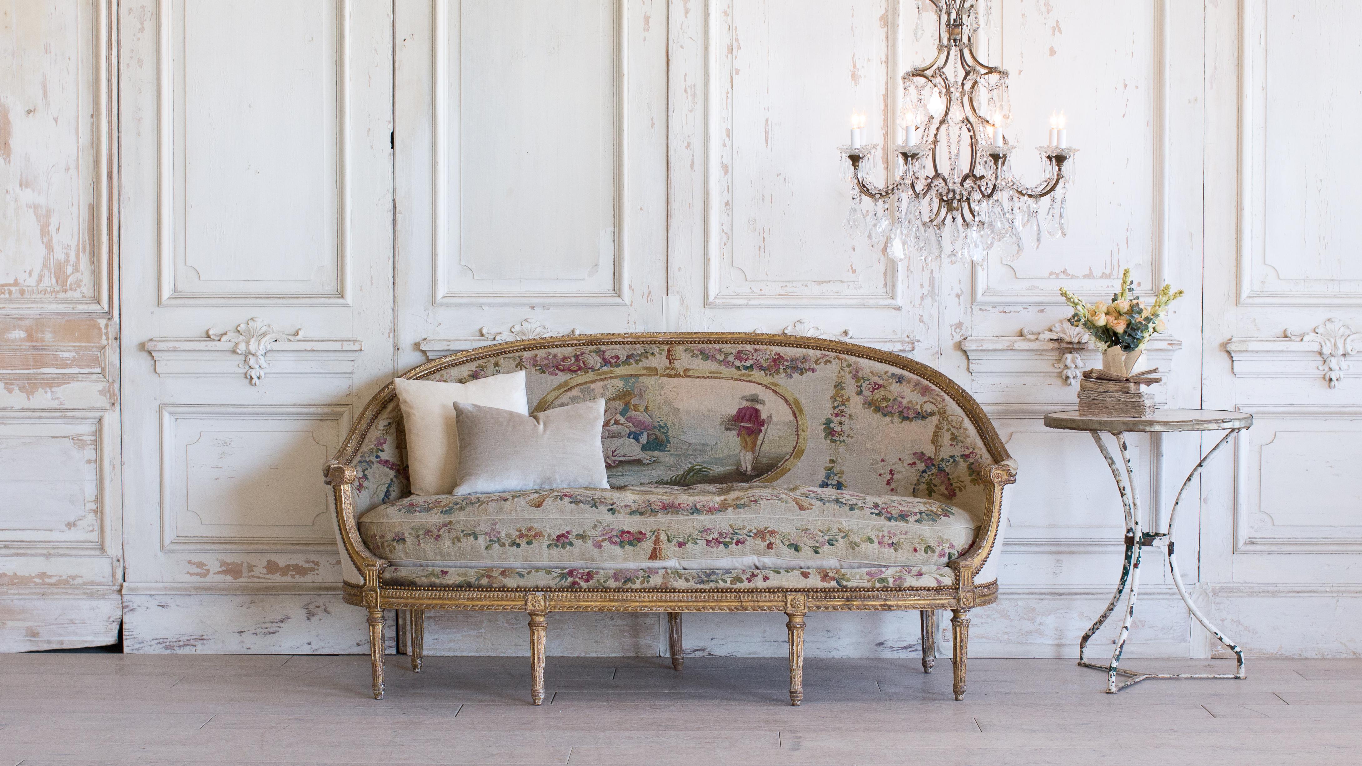 Divine antique Louis XVI oval-shaped canape with original needlepoint. The beautiful scene depicts the French countryside. Amazing worn gold gilt finish and fine carving decorate the fluted legs. A glorious tribute and statement piece.