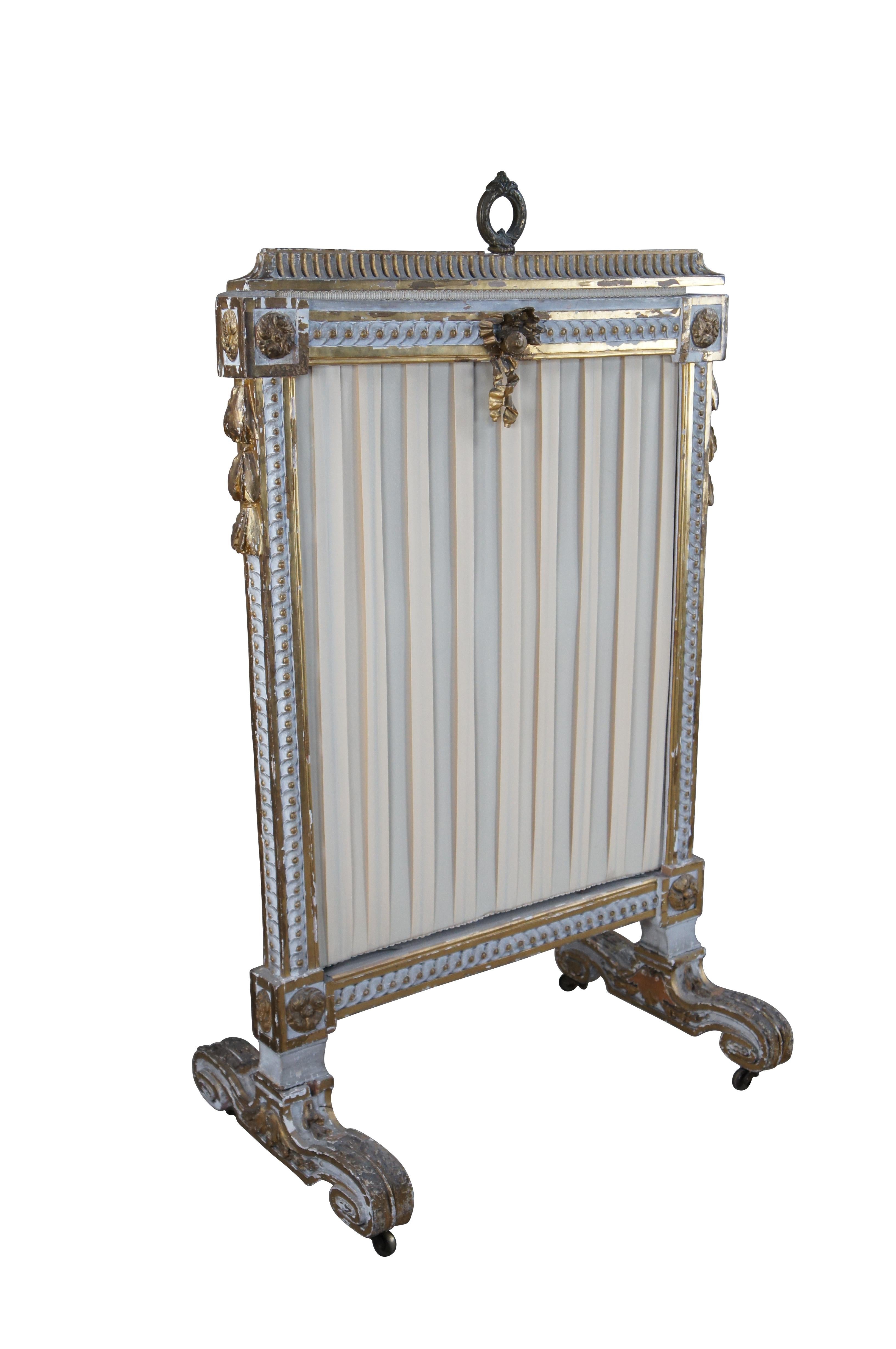Antique early 19th century Louis XVI fire screen / hearth ware.  Made of wood featuring Neoclassical styling with gold gilt carved ribbons / bows and floral acanthus designs.

Dimensions:
27
