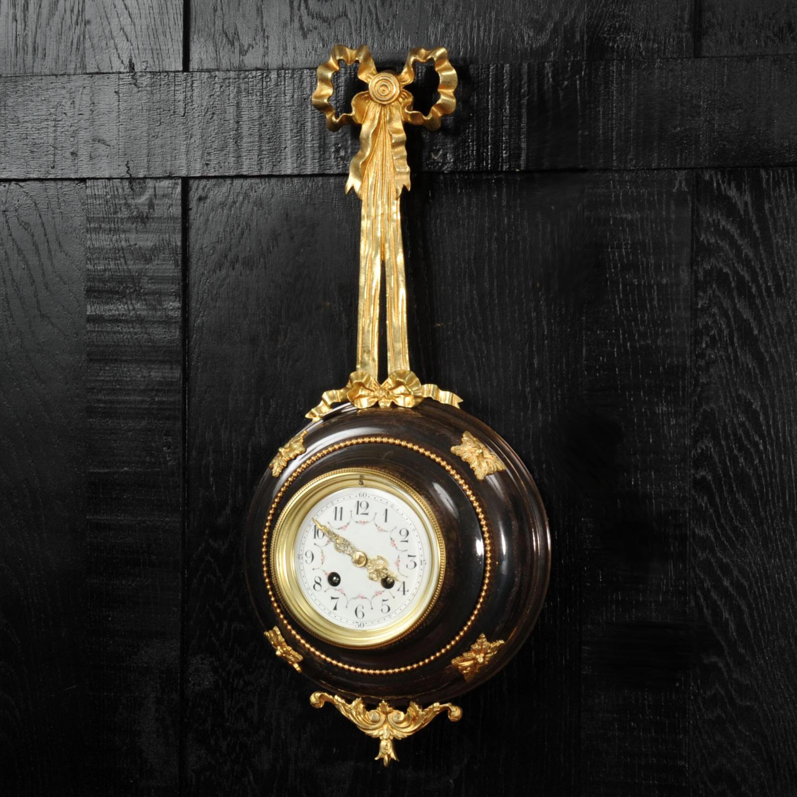Louis XVI Ormolu and bronze cartel wall clock.
~ French - Circa 1890 ~

~~ Excellent condition, fully overhauled ~~

A superb cartel wall clock in the style of Louis XVI. It as formed as a round bronze body housing the movement suspended from