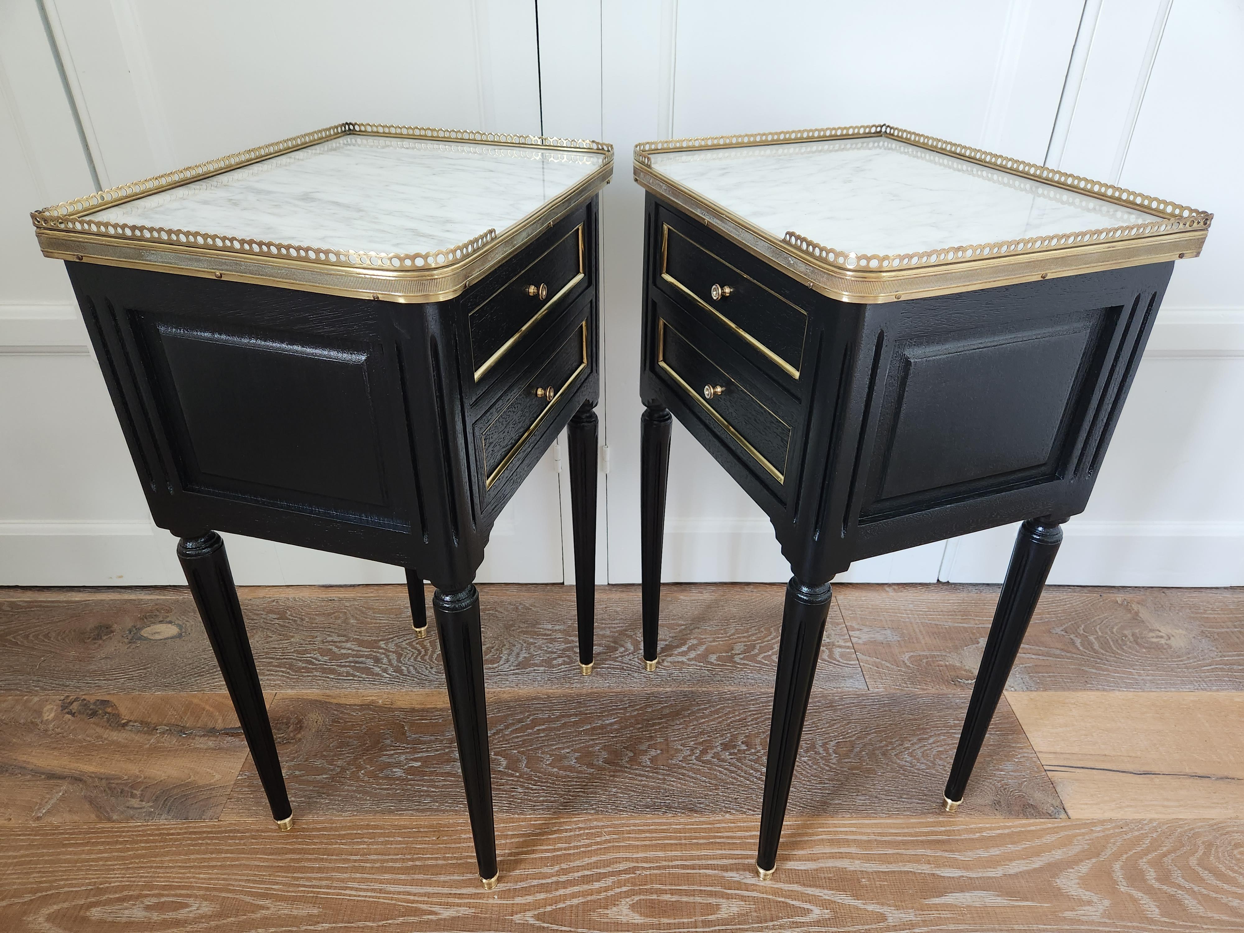 Paire de tables de nuit ou tables d'appoint de style Louis XVI surmontées d'un marbre de Carrare, pieds cannelés terminés par des sabots en bronze doré.
Galerie en laiton et deux tiroirs en façade.