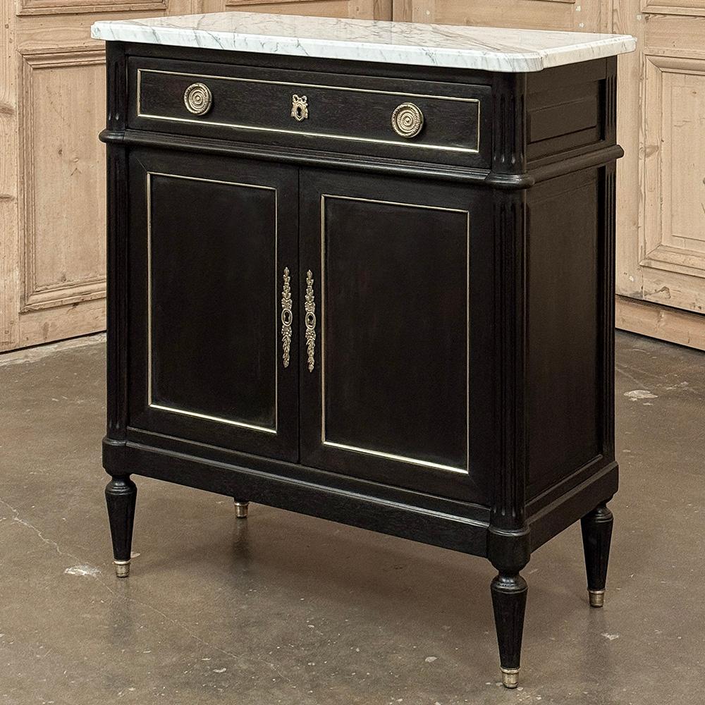 L'Antique French Louis XVI Petite Mahogany Buffet con marmo di Carrara presenta una finitura scura, quasi ebanizzata per un grande contrasto.  Rivestito in marmo di Carrara smussato con lussuose venature grigie, presenta un'architettura rettilinea