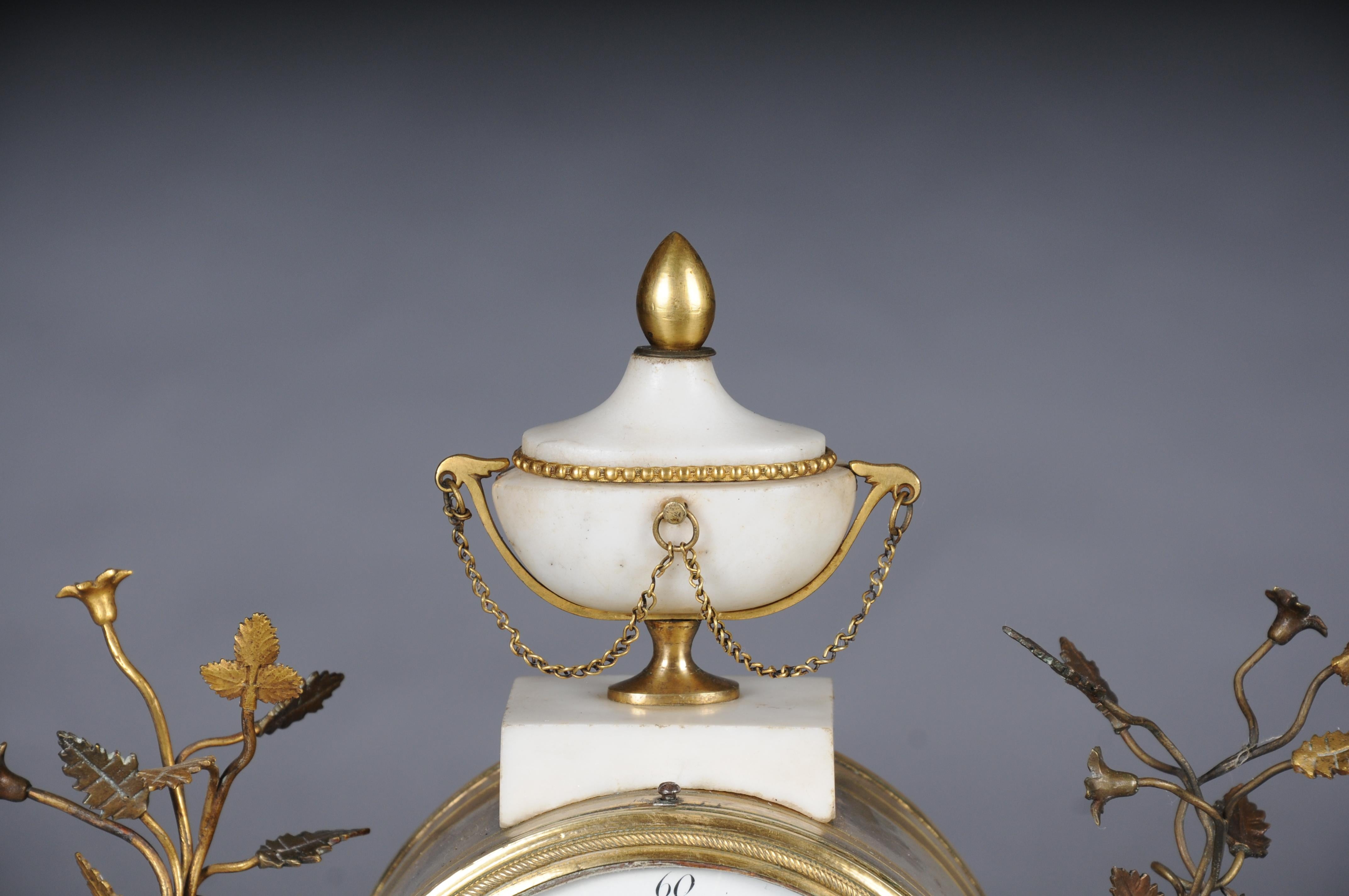Antique French Louis XVI portal clock, Paris, circa 1880
White and black marble, bronze, gilt. On gyratory feet and a recessed base, two angular baluster columns crowned with vases and appliqués of Medusa masks support the round clock case, which is