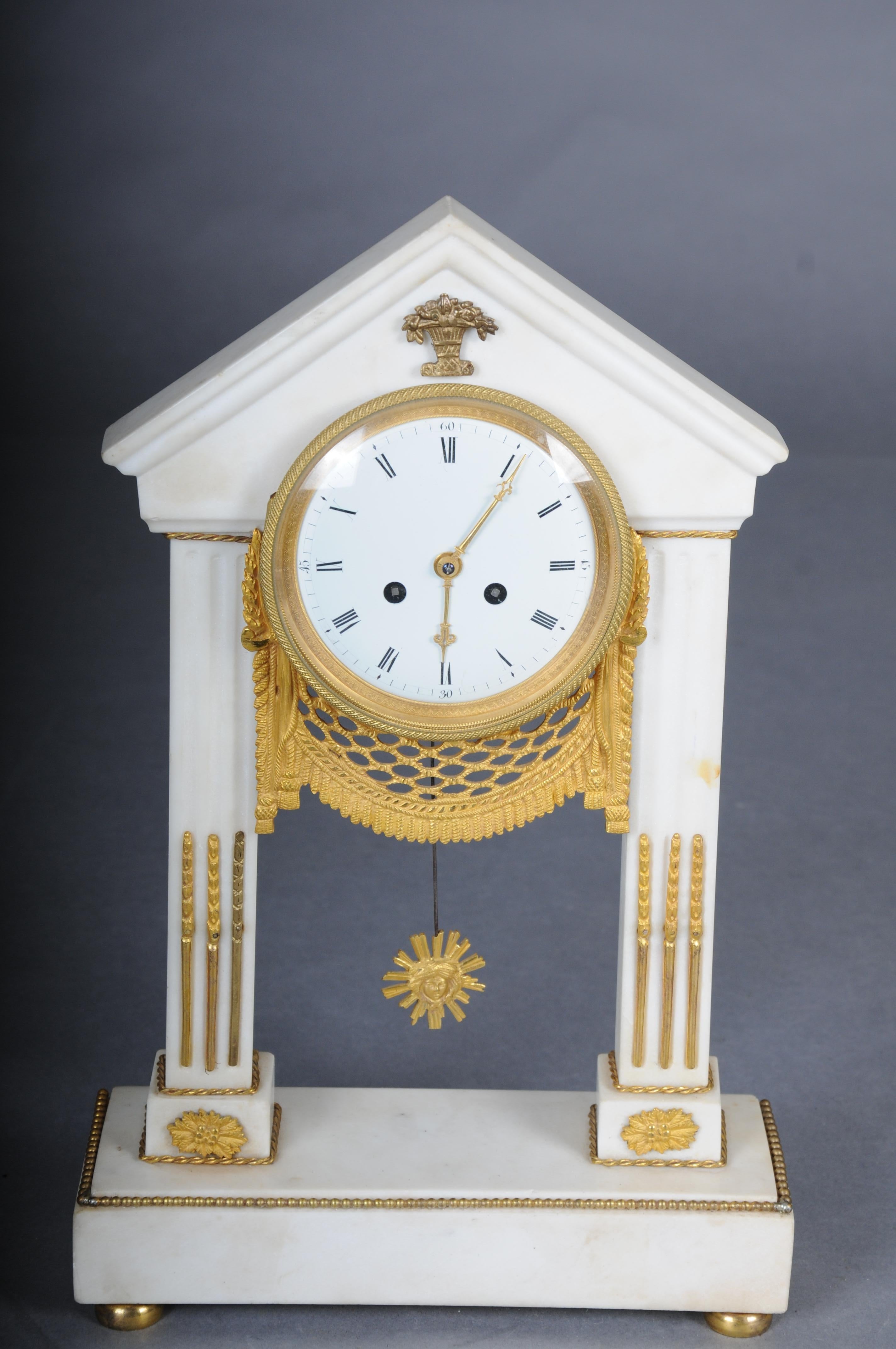 Antique French Louis XVI portal clock, Paris, circa 1880
White marble, bronze, and gilt. Two square baluster columns, crowned with a sloping roof, support ball feet and a recessed base. The clock case is round and framed by a curtain garland at the