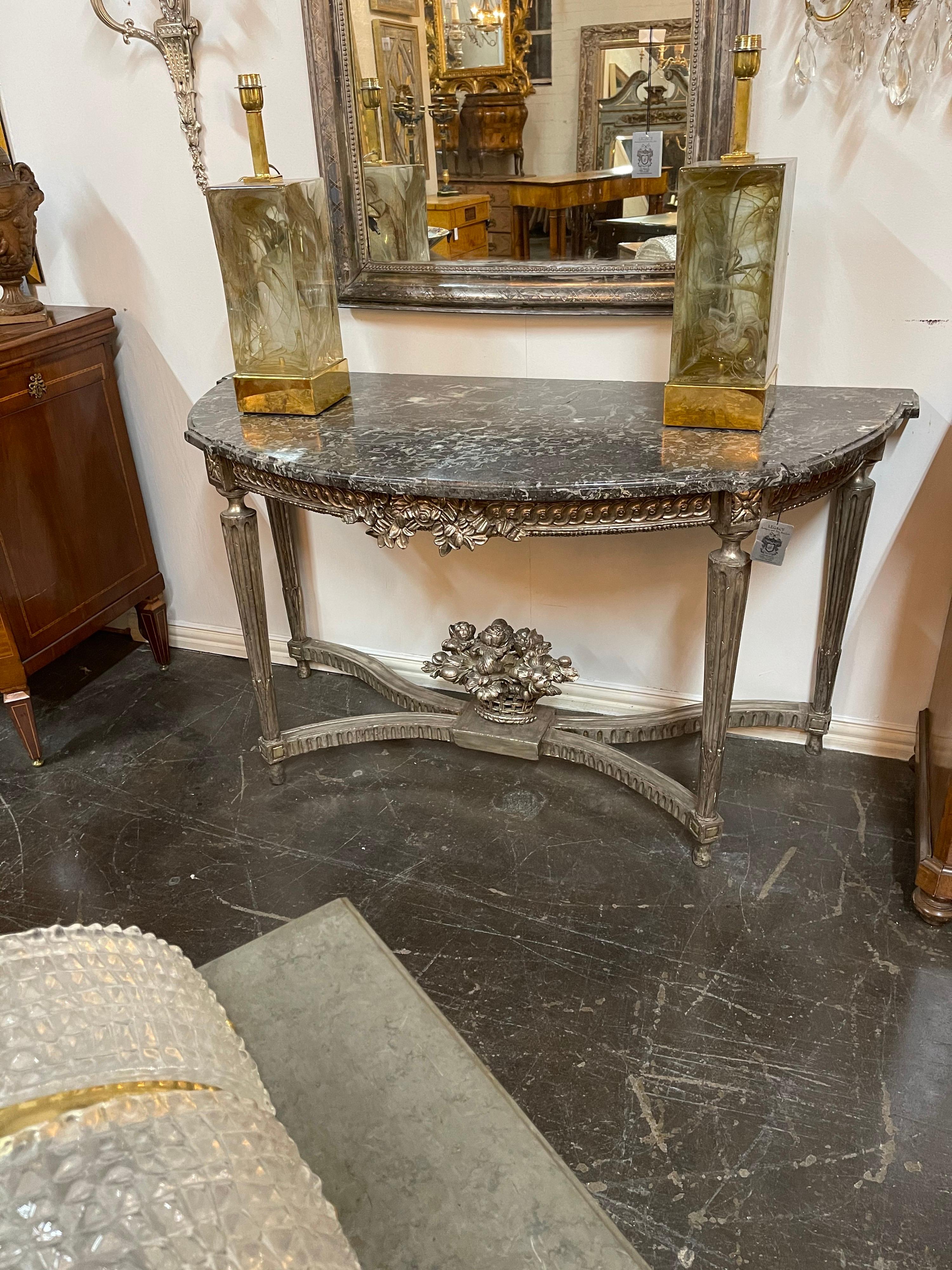 Superb 19th century French Louis XVI style silver gilt carved wood console table with a fine quality shaped marble top. The frieze nicely carved and centred by leaf accents. 

The entire on tapering fluted legs held by a contoured stretcher
