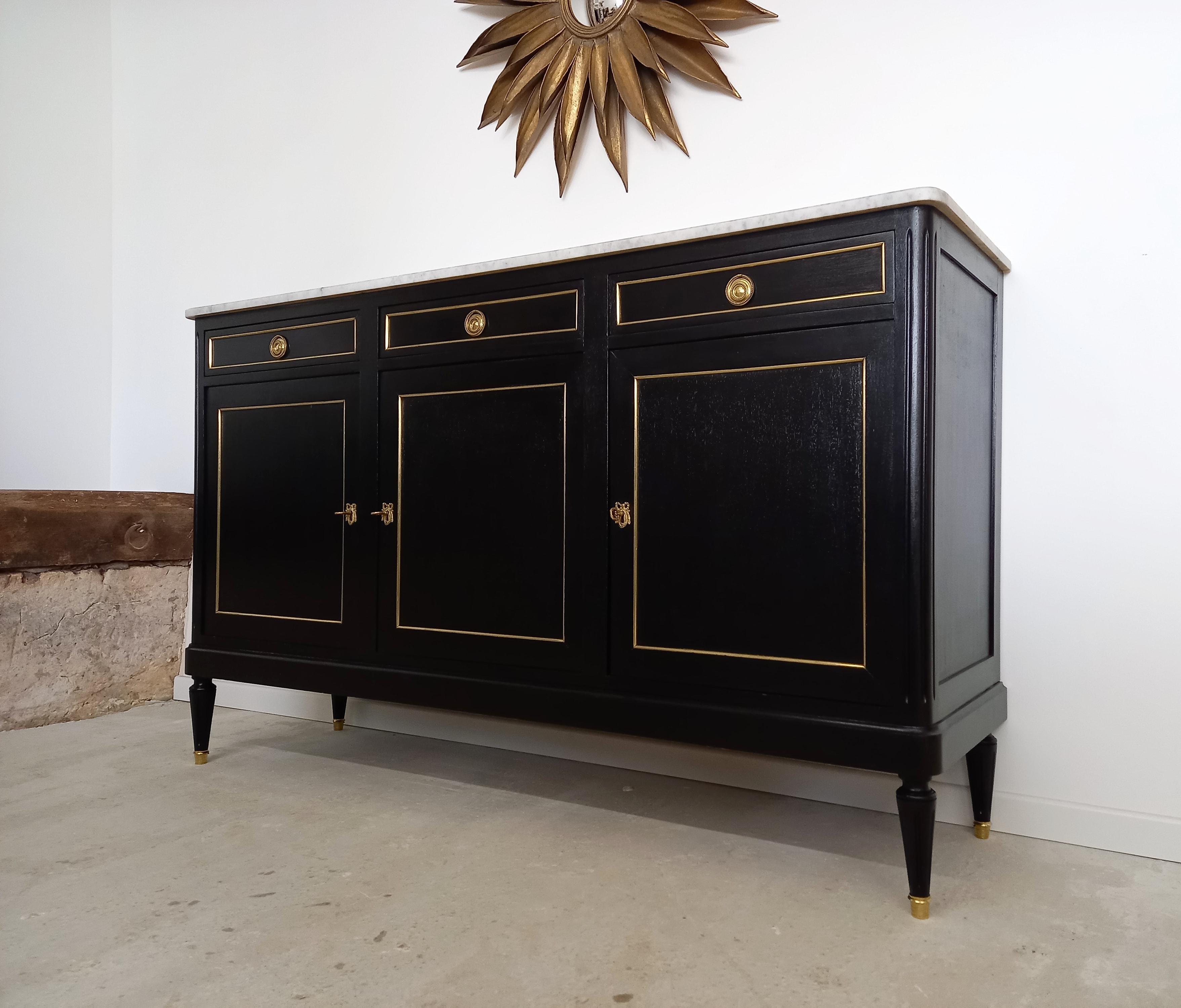 Antique French Louis XVI style buffet topped with a white Carrara marble, fluted legs finished with golden bronze clogs and thorough dressed in bronze and brass details.
Three dovetailed drawers, and doors with two removable shelves adjustable to