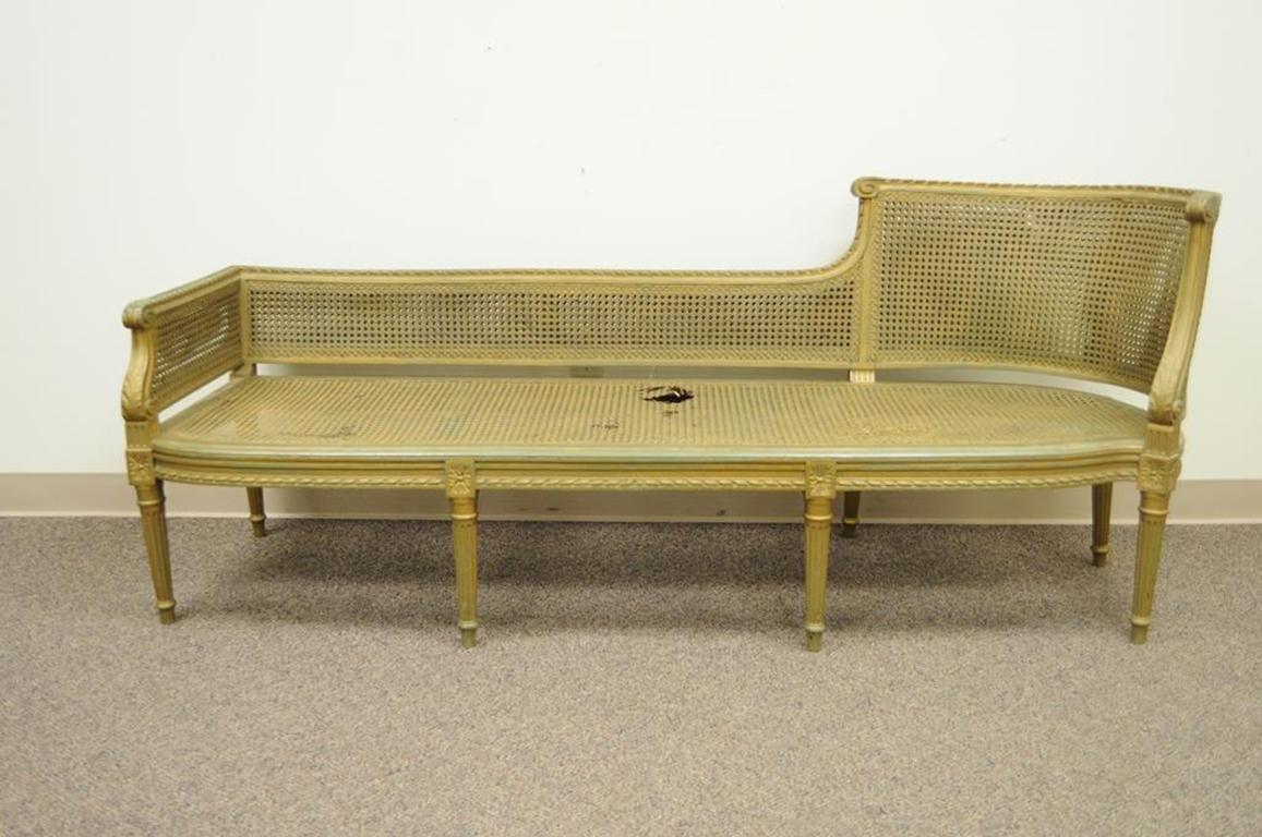 Antique French Louis XVI style caned and carved wood chaise lounge. Item features unique and beautifully carved solid wood frame, caned seat and back, and very unique overall form, circa 1900. Measurements: 30