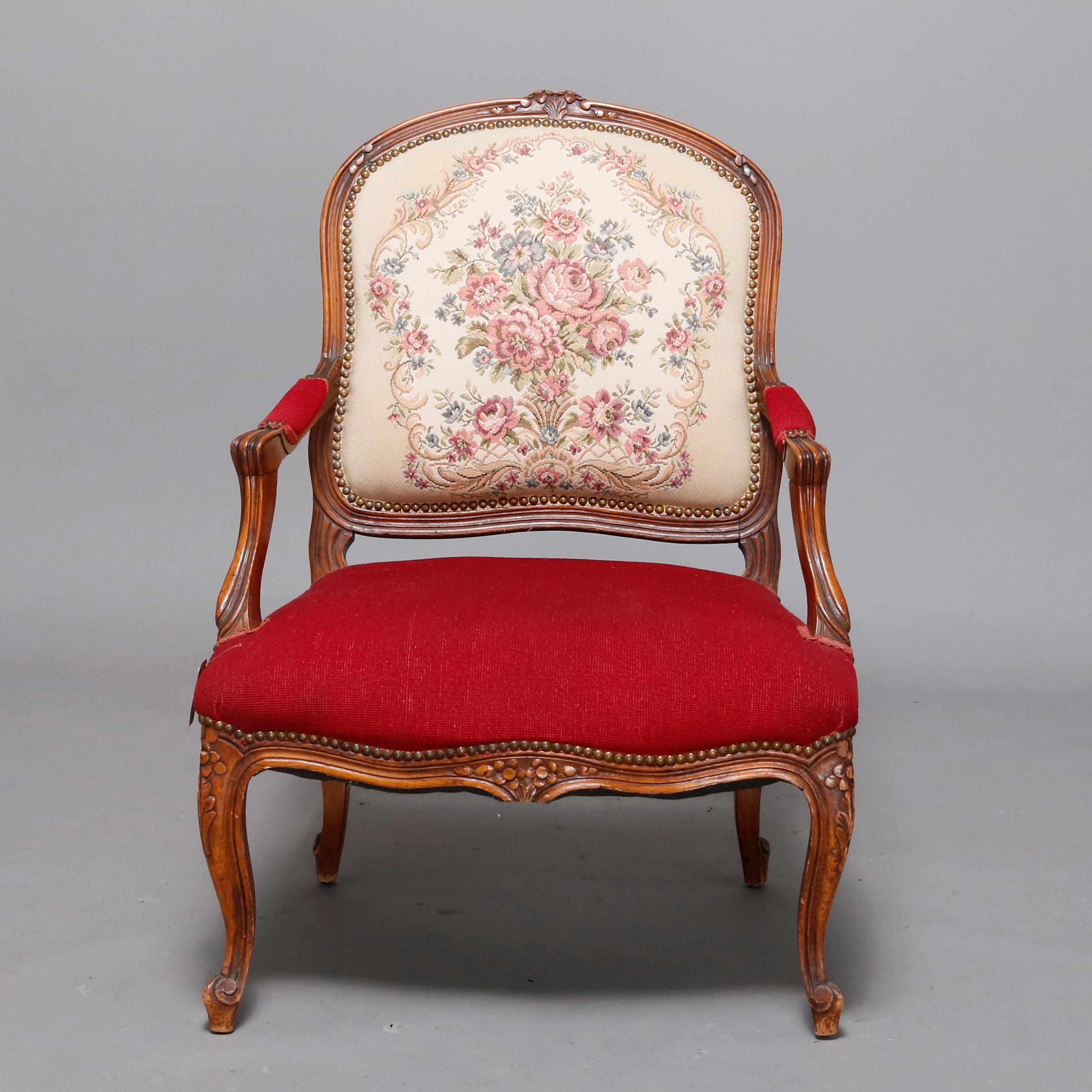 An antique French Louis XVI style armchair offers carved fruitwood frame with foliate crest surmounting medallion back with floral needlepoint upholstery surmounting covered arms and seat in complementing solid and raised on cabriole legs