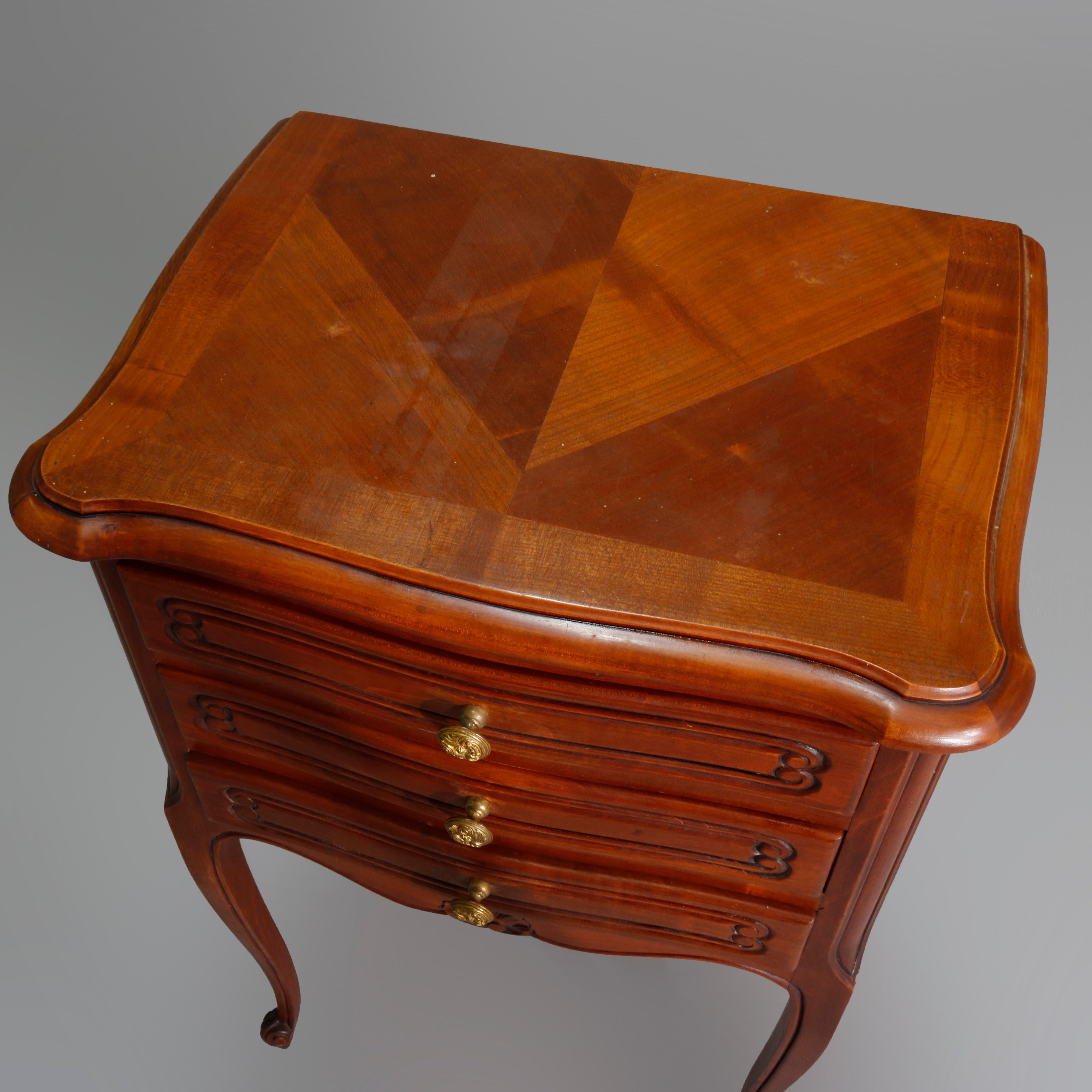 Vintage French Louis XVI style carved walnut side stand with shaped parquetry top over triple drawers having incised scroll decoration, apron with carved shell, raised on cabriole legs with scroll feet, 20th century

Measures: 27.25