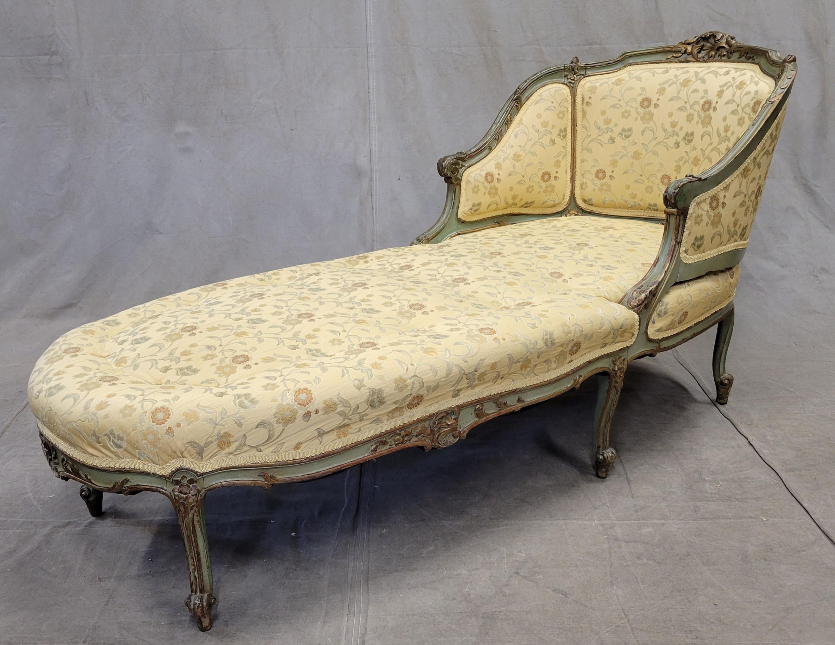 An absolutely stunning antique 19th century Louis XV style chaise lounge with modern upholstery. The chaise frame is sturdy and stunning, painted in shades of green and gold. The modern brocade upholstery in shades of creamy pale yellow with accents