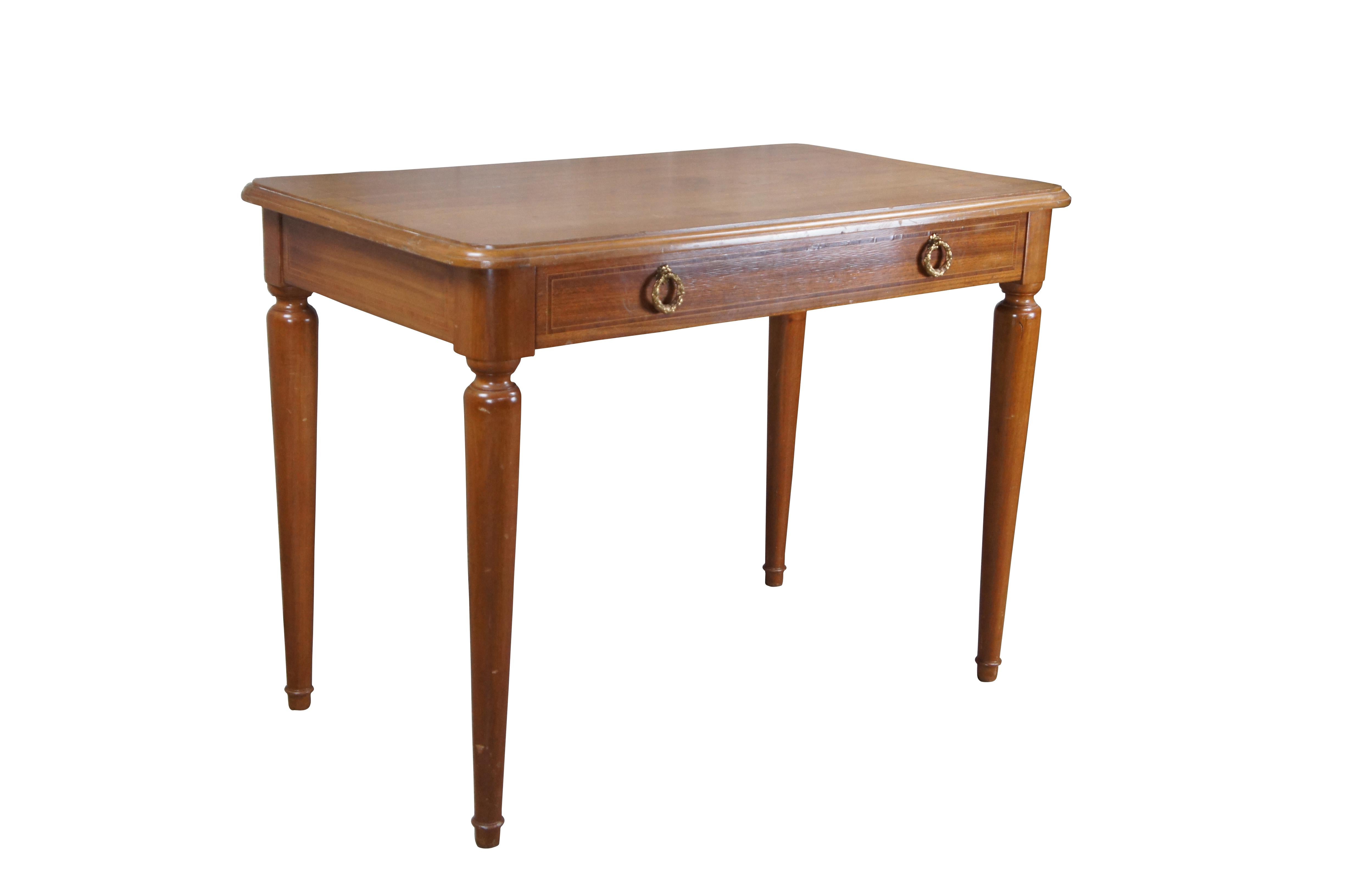 Antique 1930s French Louis XVI style cherry desk with dovetailed drawer. Made from cherry with crossbanded inlay and ormolu drawer pulls. The desk is supported by turned and tapered legs.

Dimensions:
23.5
