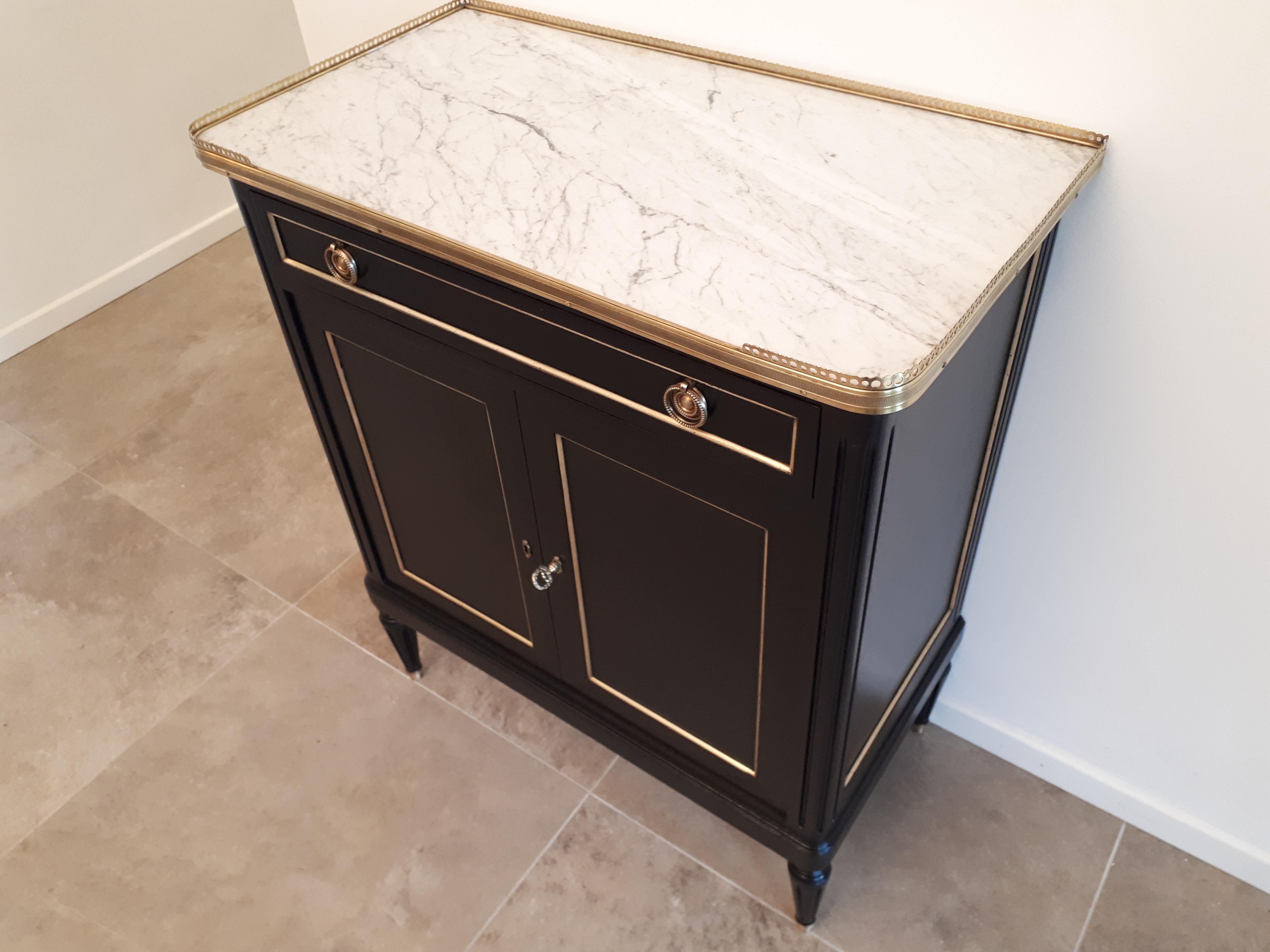 Antique French Louis XVI style bar buffet and topped with a white Carrara marble, fluted legs finished with golden bronze clogs.
One drawer, two doors and the key.
Perfect to create a small whiskey bar in the living room.