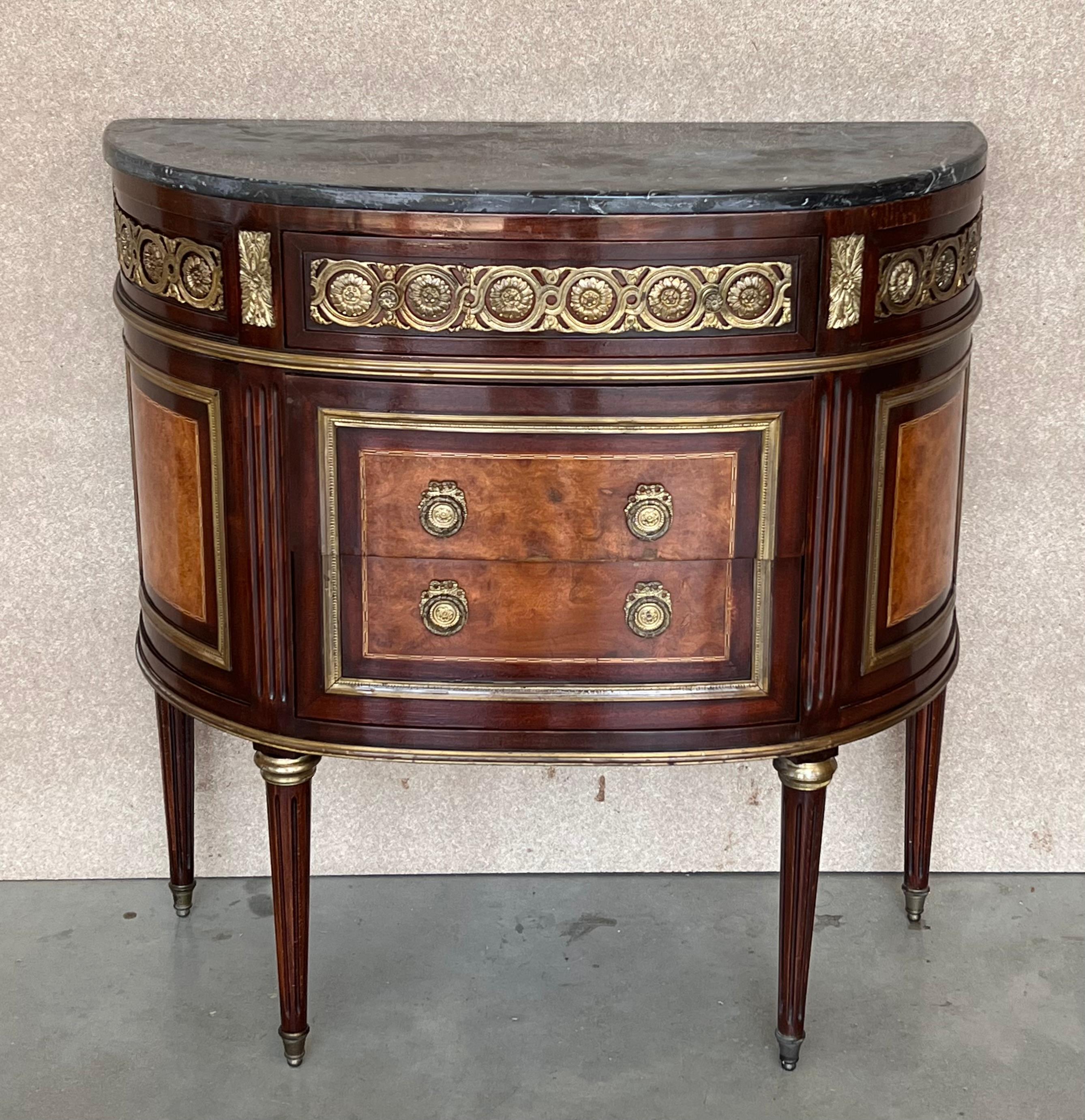 Louis XVI style gilt bronze mounted commode 19th century marble top of breakfront form having three drawers with working key. The bronze mounts depict leaf and berry design. The sides curve gracefully toward the back of this cabinet. Drawers slide