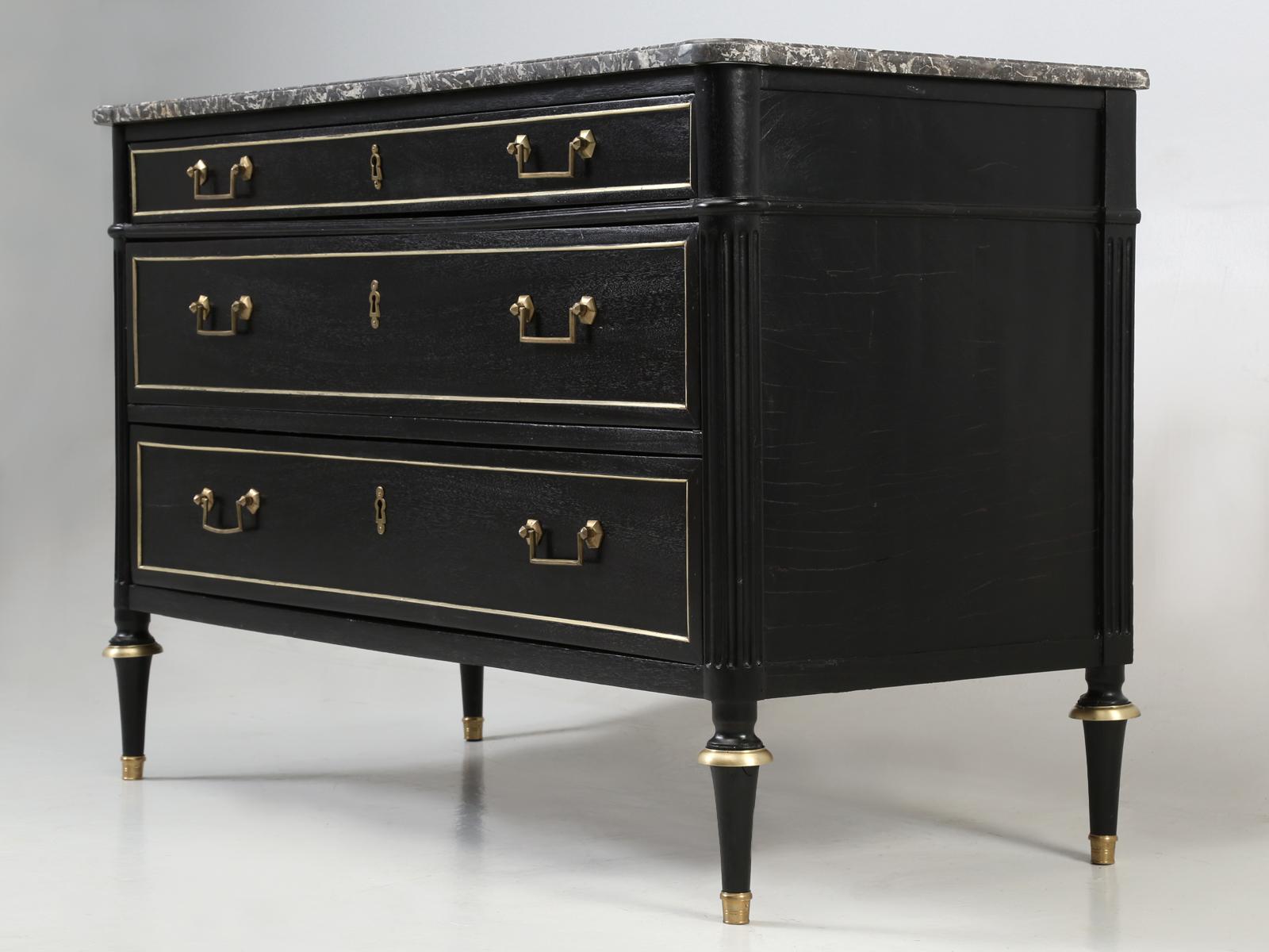 Antique French Louis XVI style commode, with its original grey marble top. Our in-house Old Plank restoration department, hand-stripped the entire antique French commode and applied a real French ebonized finish, where the grain of the mahogany and