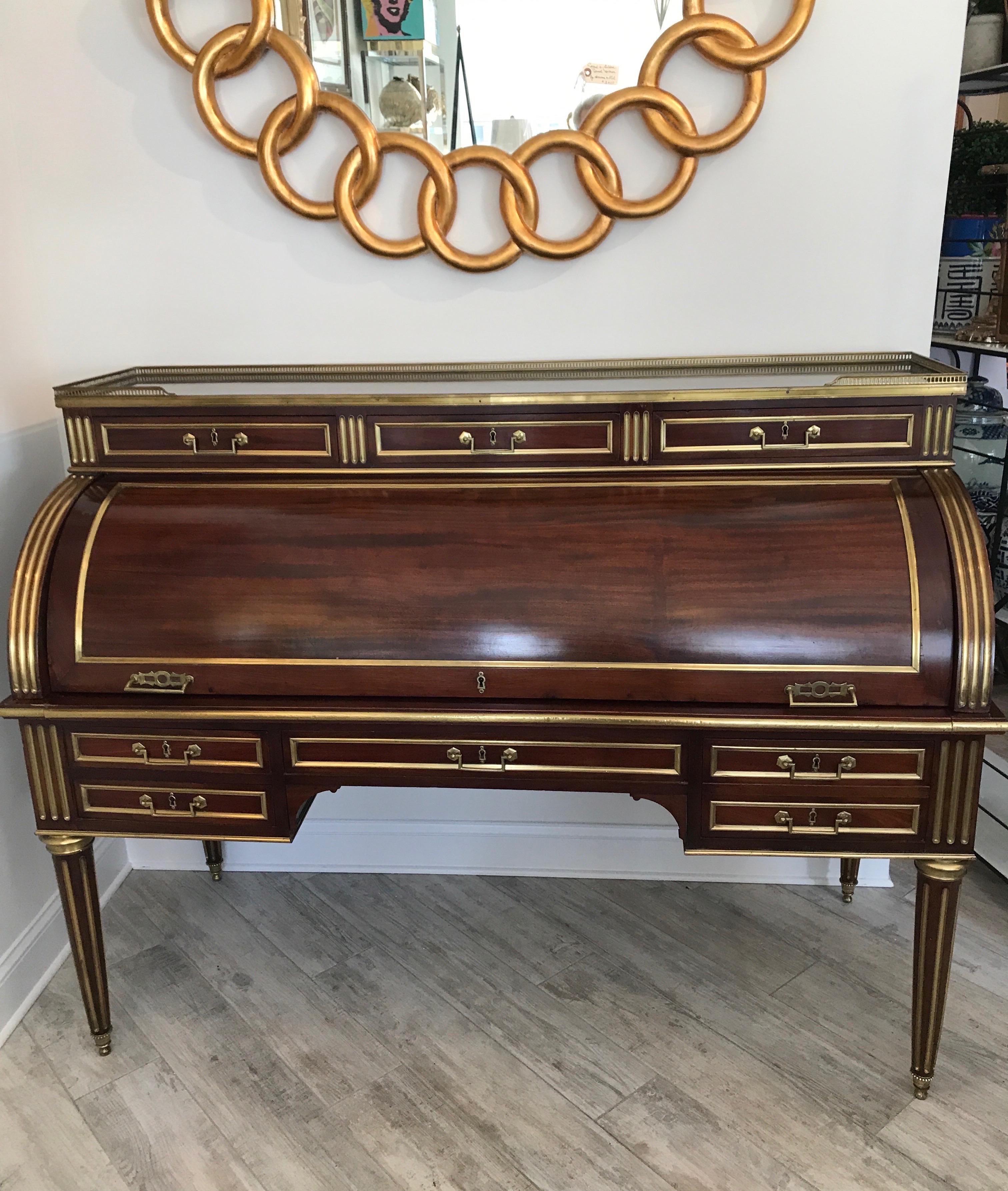 Striking antique French cylinder desk with many drawers and compartments. Pull out leather writing surface. Galleried marble top and fitted with brass inlay's.