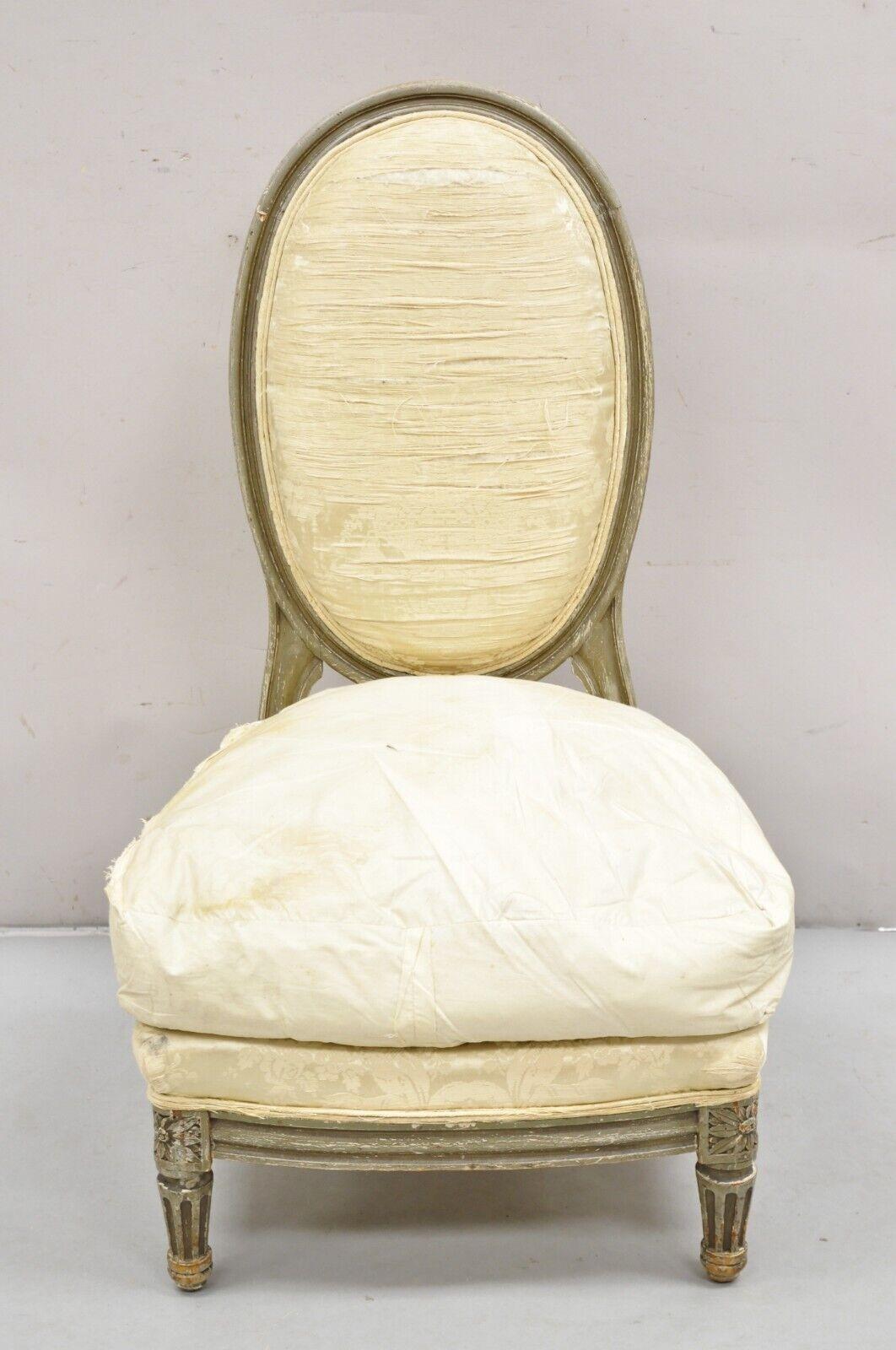 Antique French Louis XVI Style Distress Painted Boudoir Slipper Low Chair attributed to Maison Jansen. Item featured is a low sleek form, solid wood frame, shapely oval back, loose down cushion, quality French craftsmanship. Circa Early 1900s.