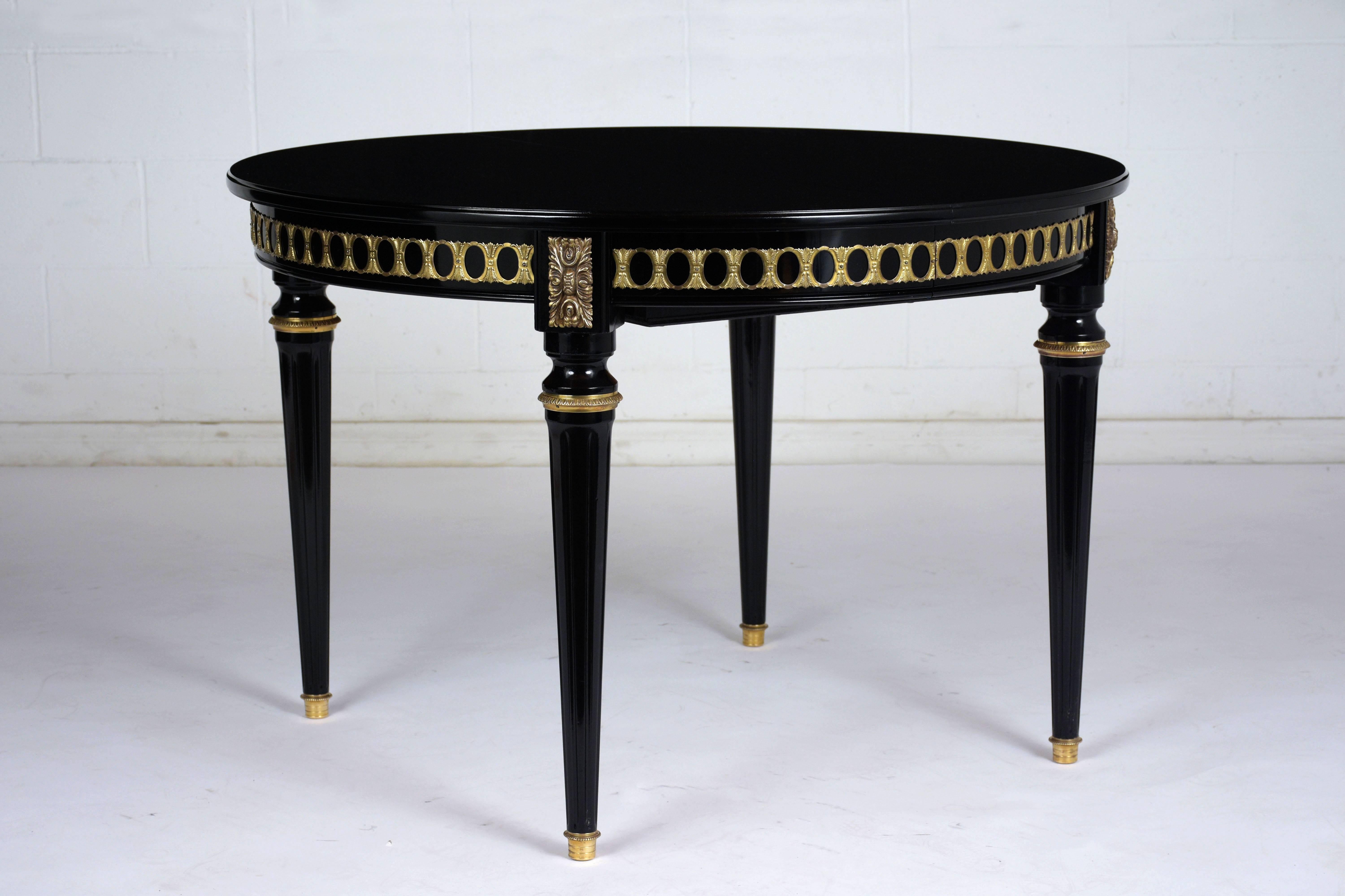 This 1920s French Louis XVI-style dining table extends to double its length with two butterfly leaves hidden within the table with a sound and practical mechanism. The mahogany table is very elegant with an ebonized and lacquered finish. The skirt