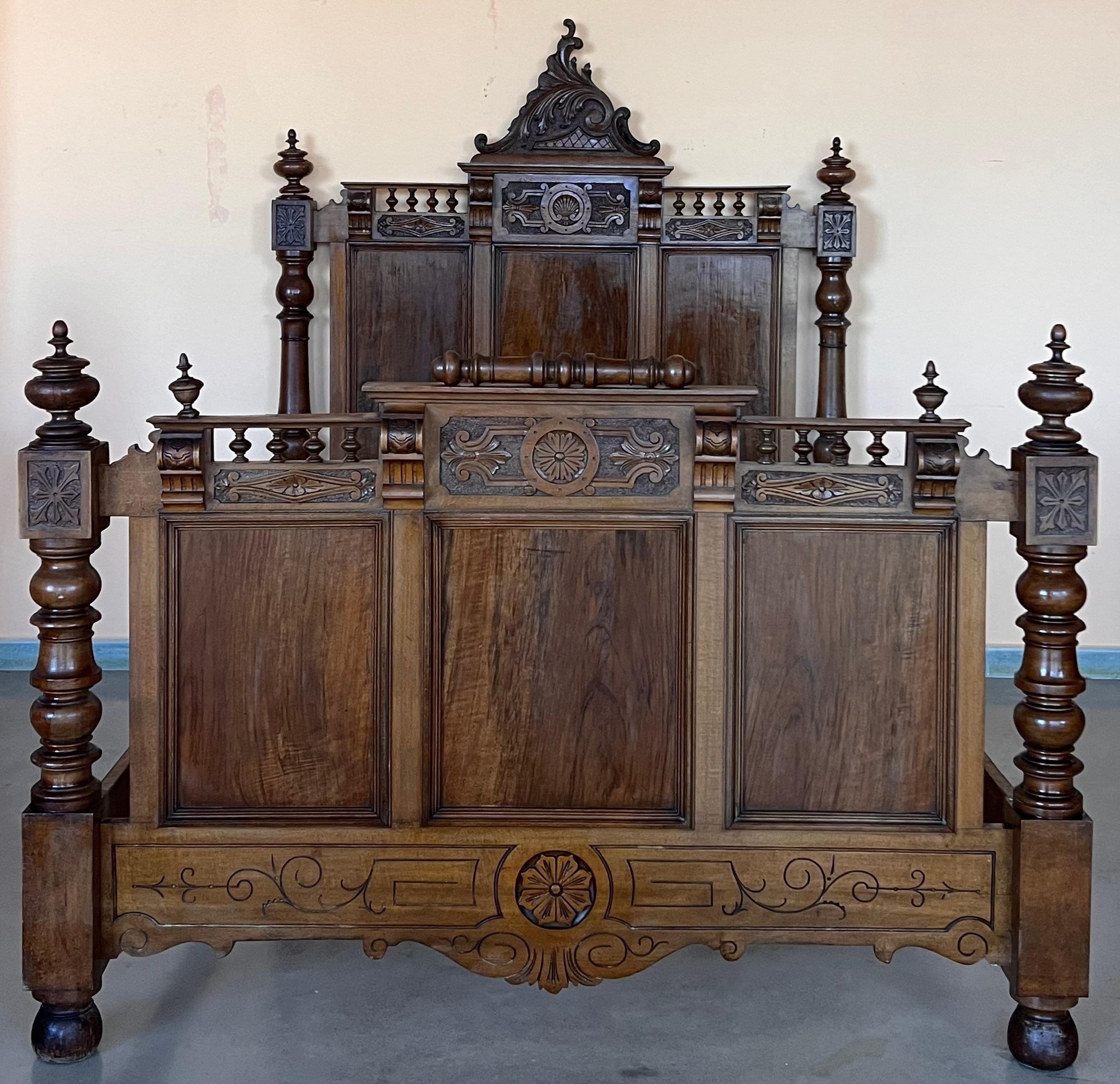 An Exquisite antique French Louis XVI full size bed. Made of Rosewood featuring foliate carved ribbon and crest with center cartouche, acorn form finials, fluted and turned columns, and carved sunflower medallion embellishments.