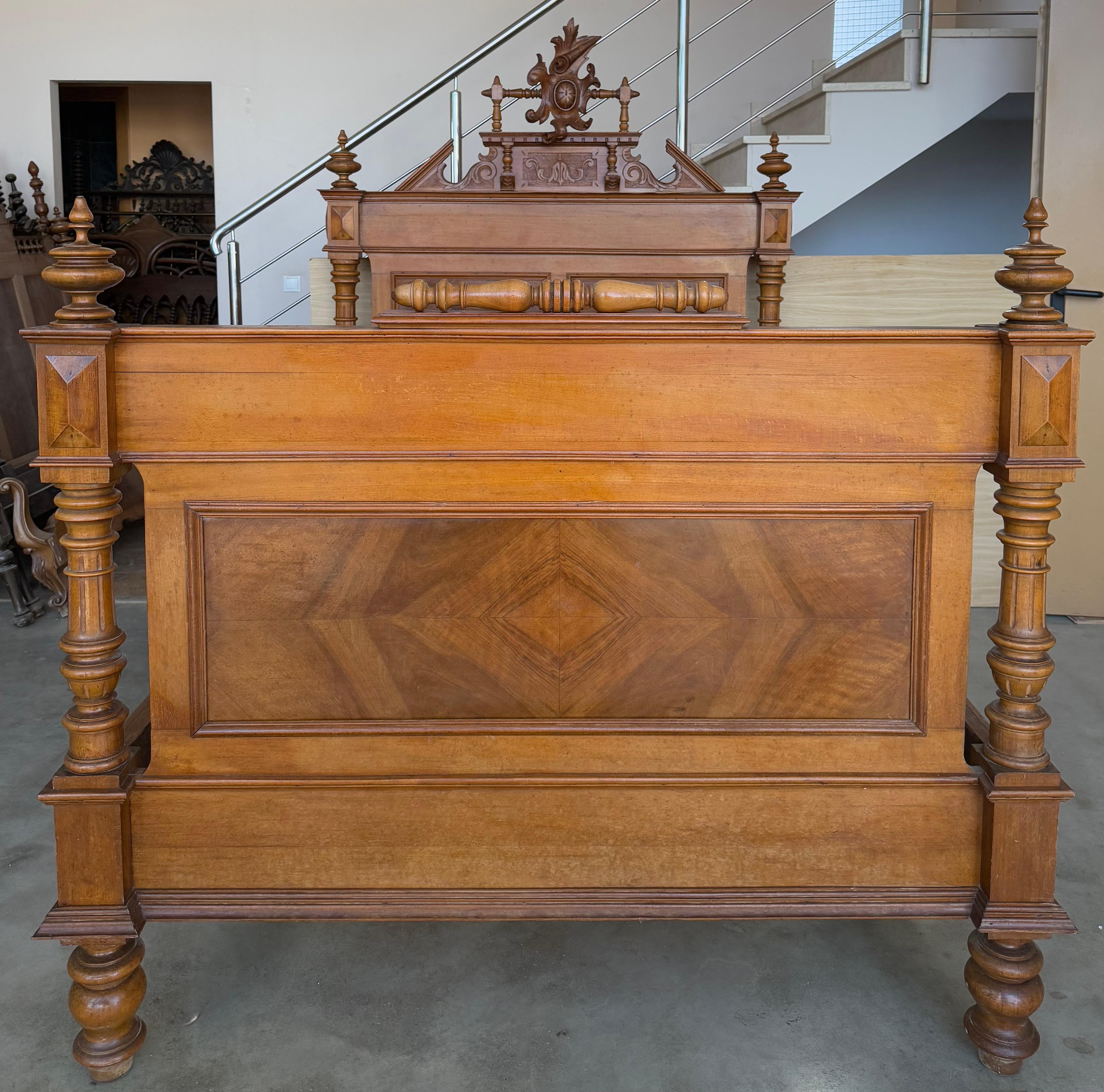 An Exquisite antique French Louis XVI full size bed. Made of Rosewood featuring foliate carved ribbon and crest with center cartouche, acorn form finials, fluted and turned columns, and carved sunflower medallion embellishments.

Height Footboard :