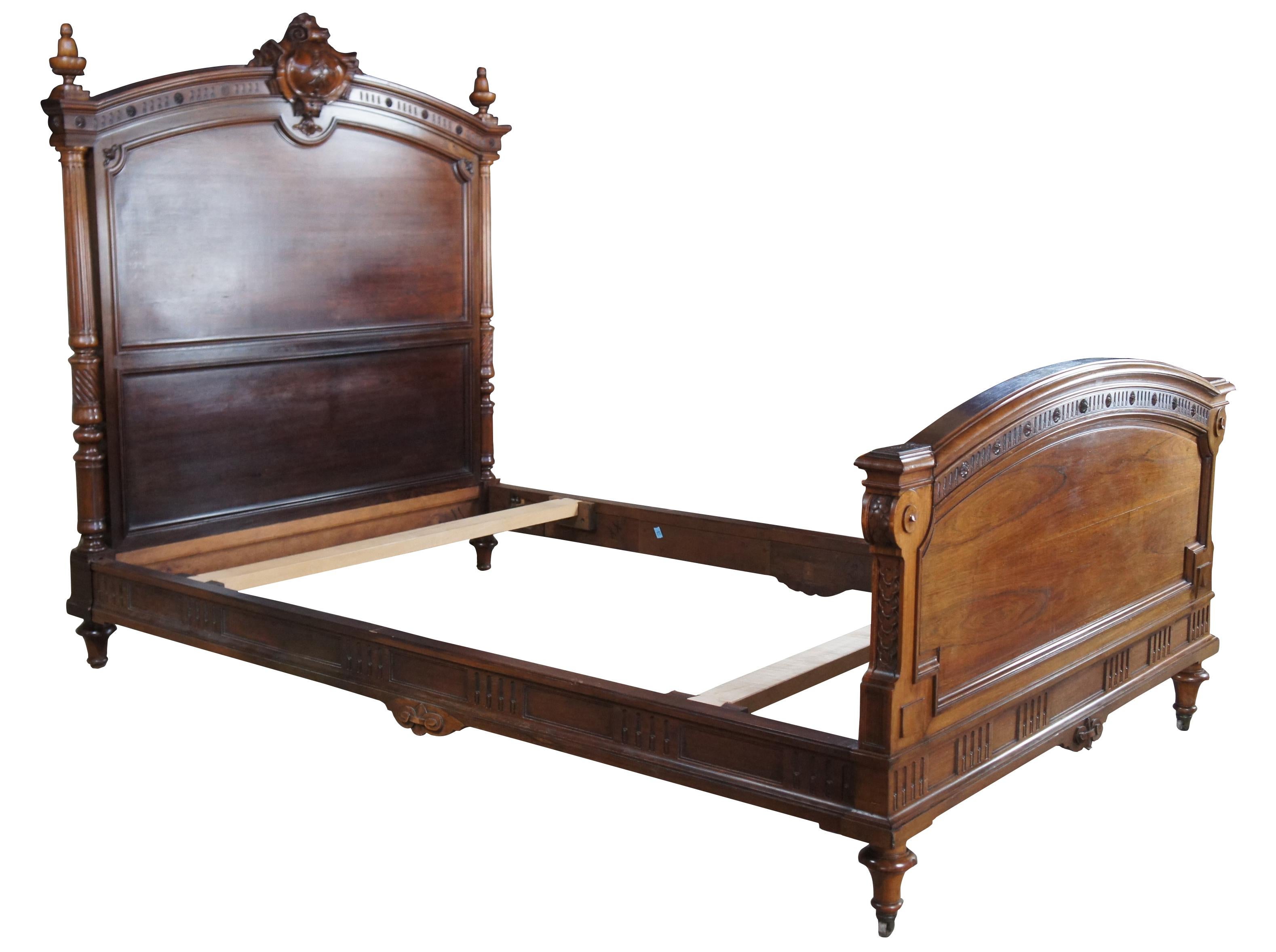 An Exquisite antique French Louis XVI full size bed. Made of Rosewood featuring foliate carved ribbon and crest with center cartouche, acorn form finials, fluted and turned columns, and carved sunflower medallion embellishments.

Measures: 86