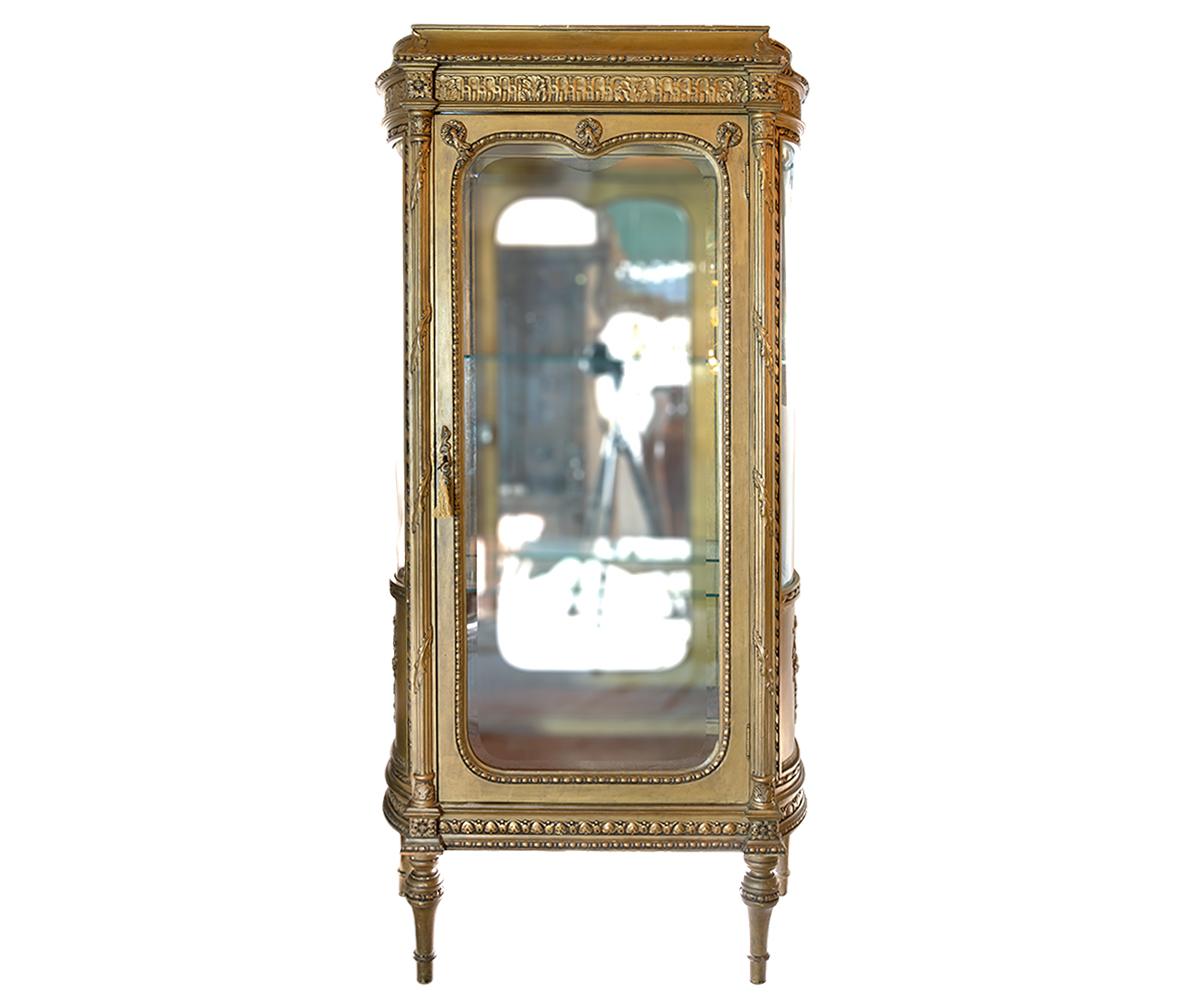 Offering this antique French Louis XVI style vitrine or display cabinet. It is the perfect size for any personal collection to add beauty and elegance to any room. Features include a rounded side glass and beveled front glass which are original to