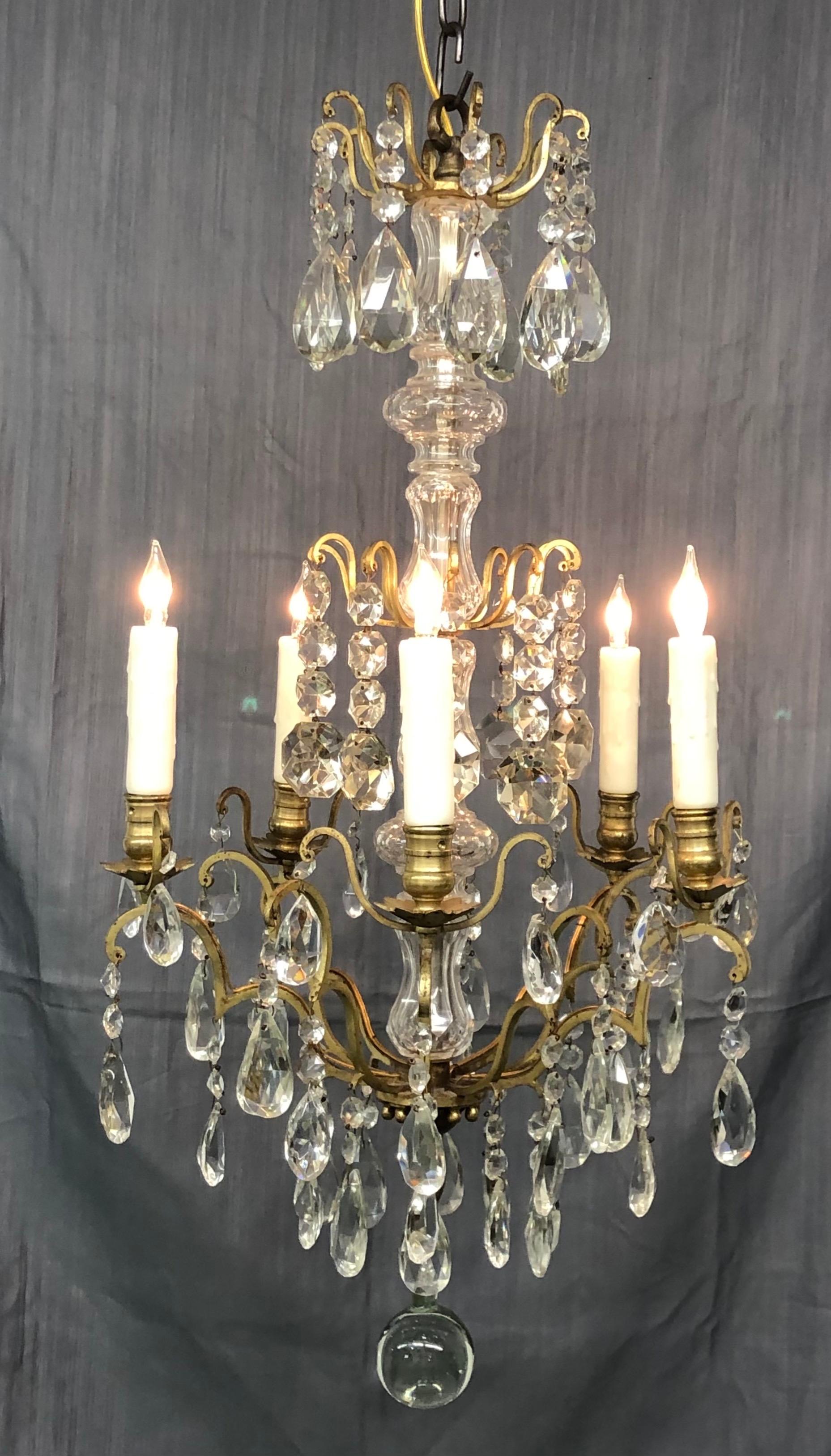 Elegant French Louis XVI style gilt bronze and cut crystal five-arm chandelier of Baccarat quality with faceted cut crystal prisms, chains and faceted cut crystal shaft.