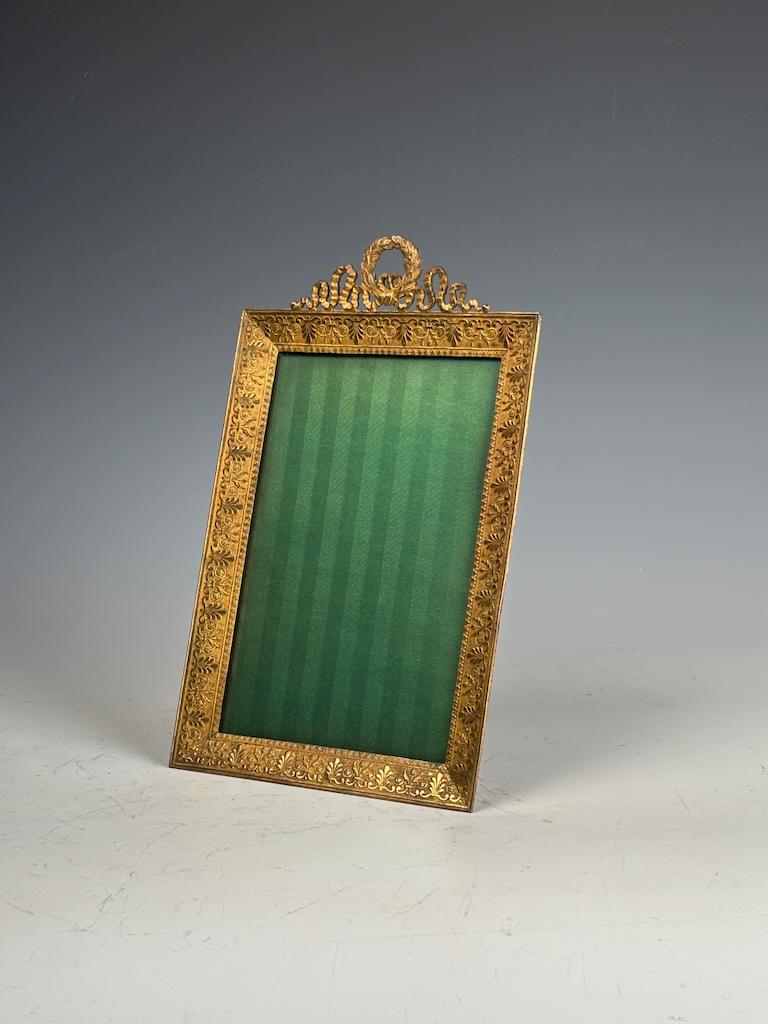 Cadre photo ancien en bronze doré du 19ème siècle - Style Louis XVI
Ajoutez une élégance intemporelle à votre Collectional avec cet exquis cadre photo en bronze doré français du XIXe siècle, magnifiquement réalisé dans le style Louis XVI. Riche en